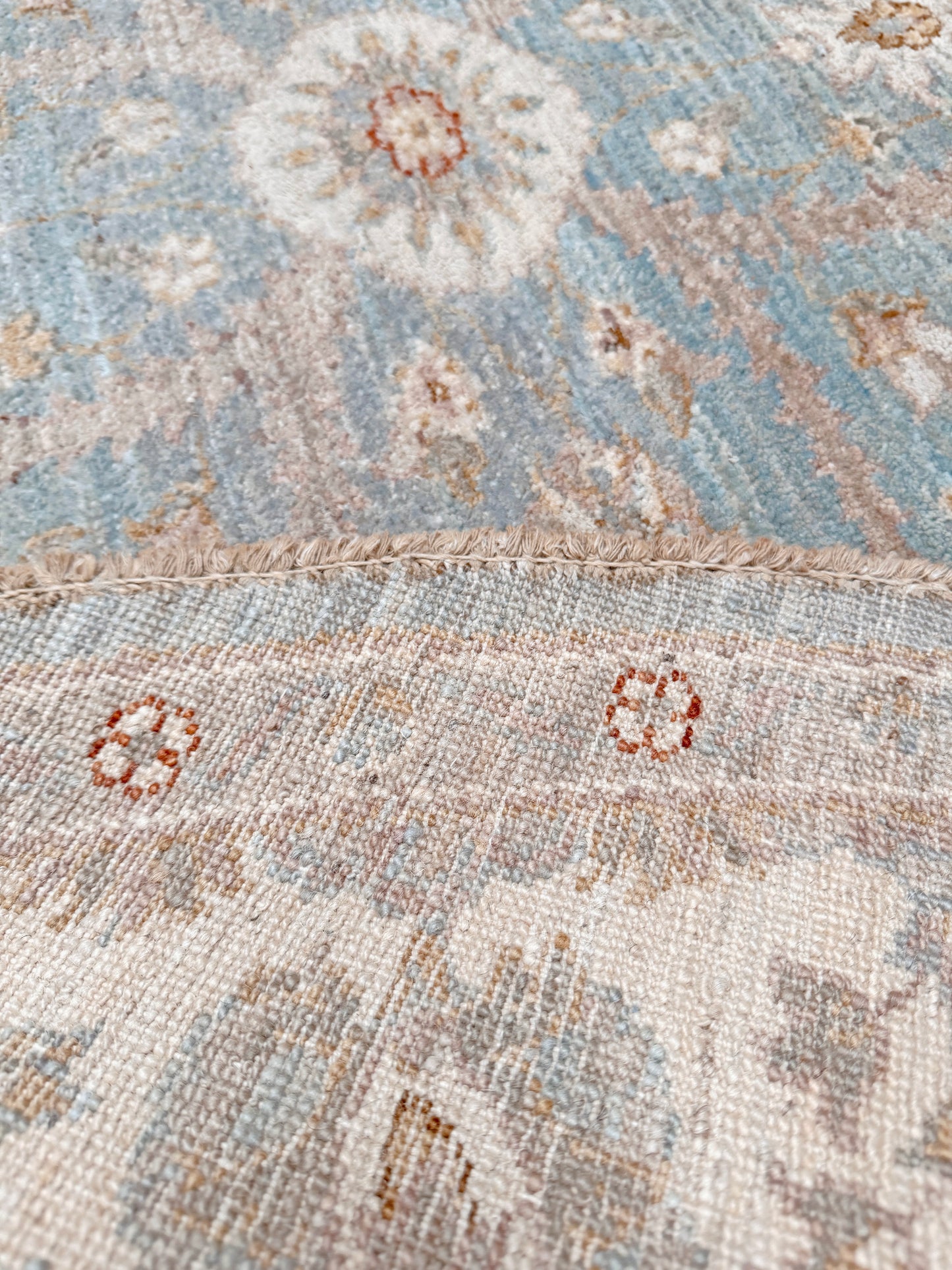 Pale blue round Turkish Oushak rug with soft colored floral details, handmade wool 5x5 round area rug from Indigo Rugs Burlingame Bay Area.