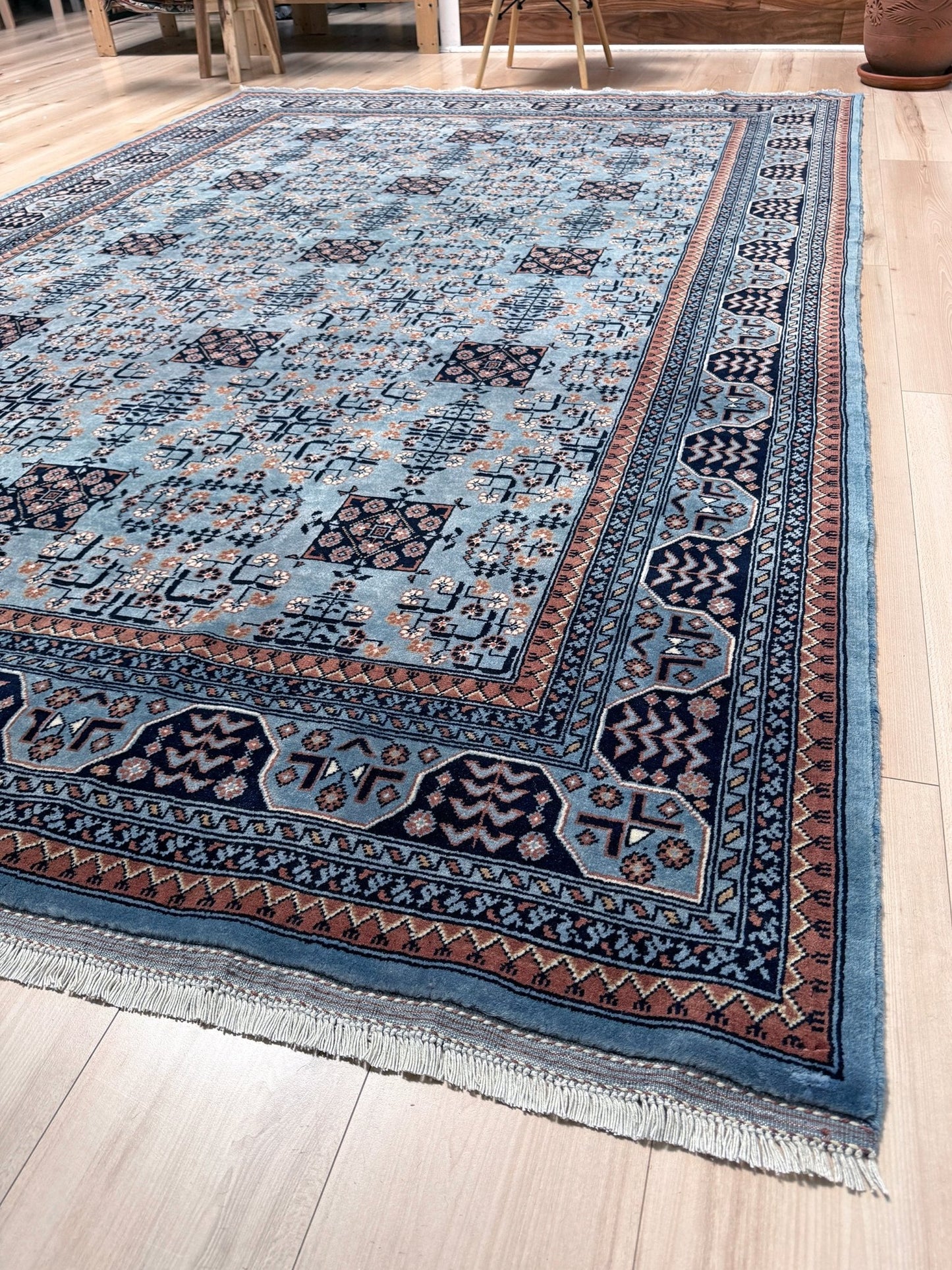 Top quality 6x9 blue Bilcik Turkmen transitional rug with intricate geometric patterns, perfect for bedroom, living room, or dining room. Handwoven with rich misty blue, deep navy, and warm terracotta hues for a sophisticated yet bold look. Available at the best rug shop in San Mateo, SF Bay Area, with free shipping. Add character and elegance to your space with this premium handmade wool rug.