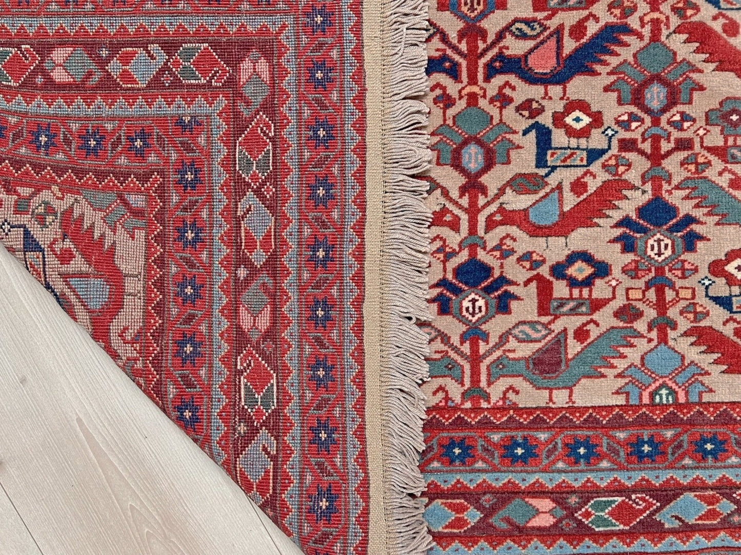 Brand new 6x9 handmade Turkish Tree of Life rug in muted peach with birds, floral motifs, coral red and blue accents, traditional wool area rug from Indigo Rugs Burlingame Bay Area.
