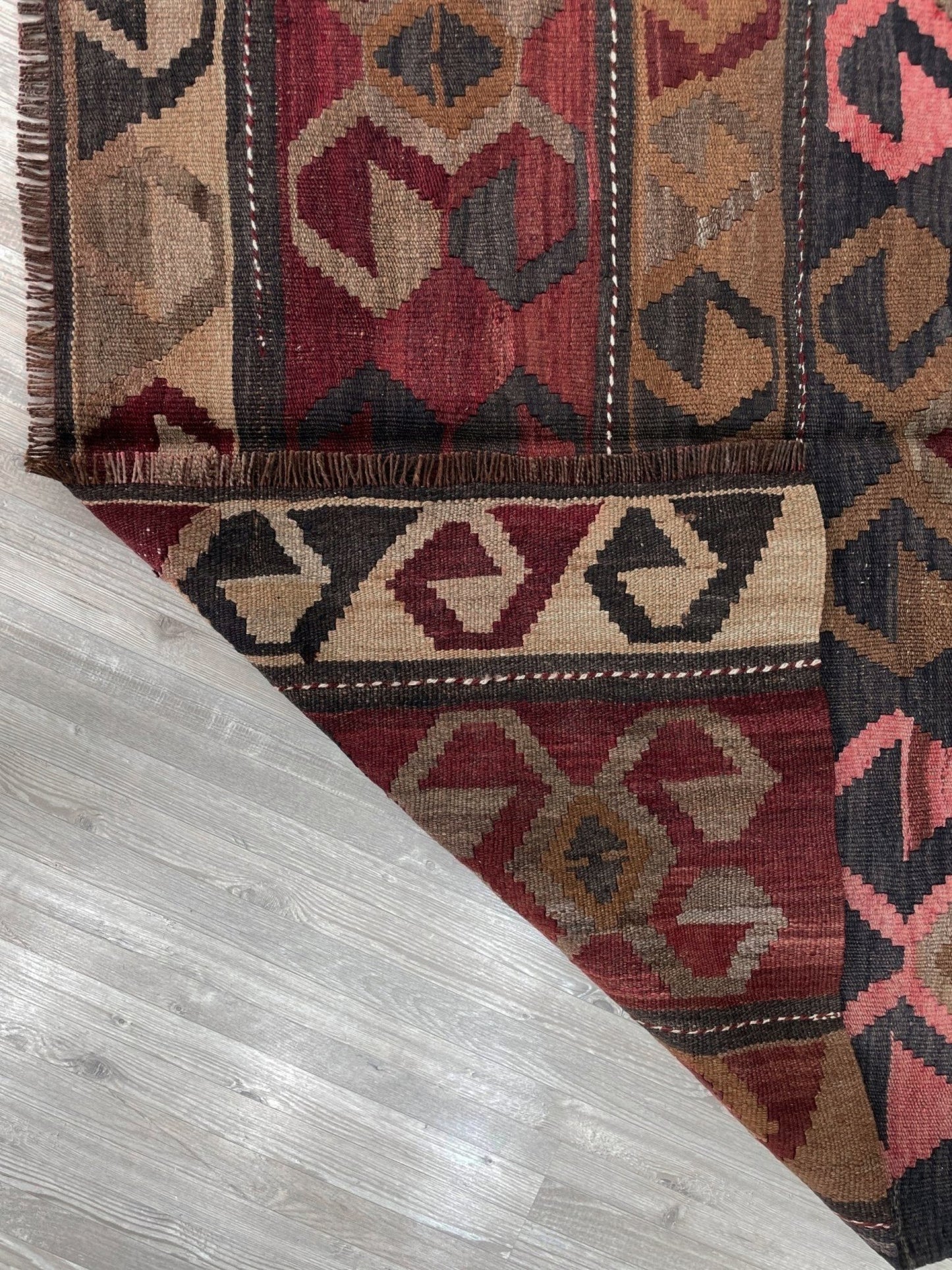 Vintage Eastern Turkish Kars kilim rug with horizontal tribal bands, hooked diamond motifs, and geometric symbols in madder red, walnut brown, 5x7.