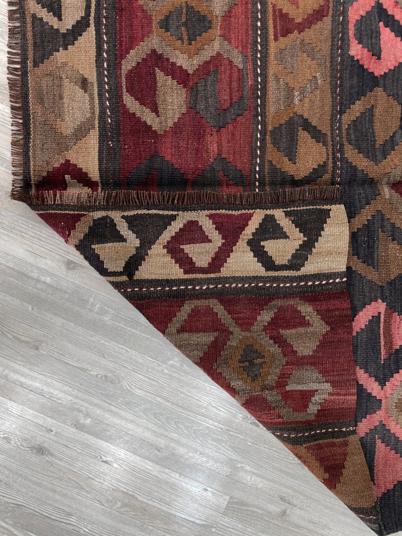 Vintage Eastern Turkish Kars kilim rug with horizontal tribal bands, hooked diamond motifs, and geometric symbols in madder red, walnut brown, 5x7.