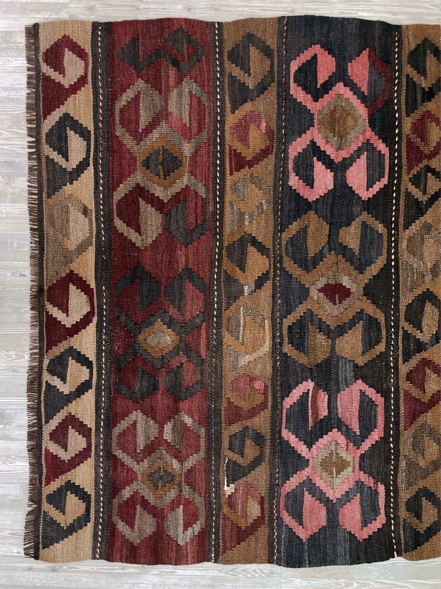 Vintage Eastern Turkish Kars kilim rug with horizontal tribal bands, hooked diamond motifs, and geometric symbols in madder red, walnut brown, 5x7.