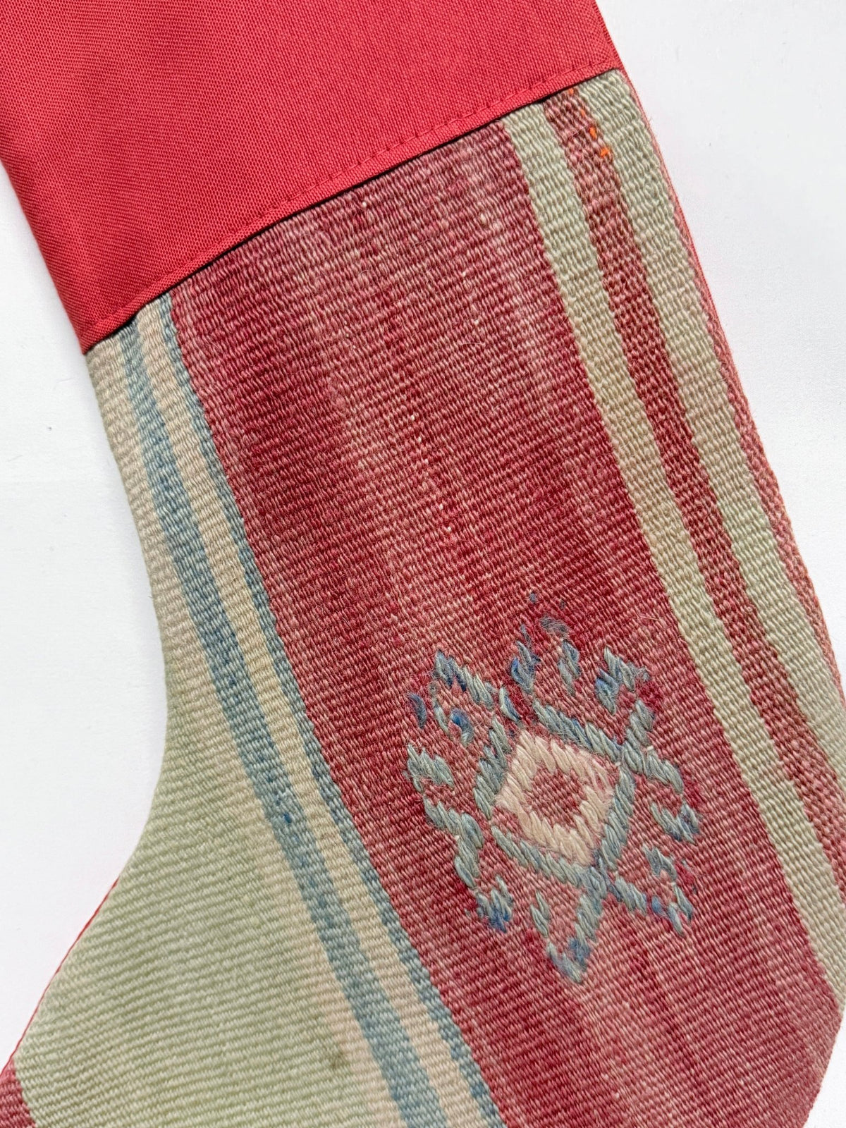 Two Christmas stockings with a rustic Southwestern pattern, featuring a red velvet cuff and hanging loops, on a solid white background.