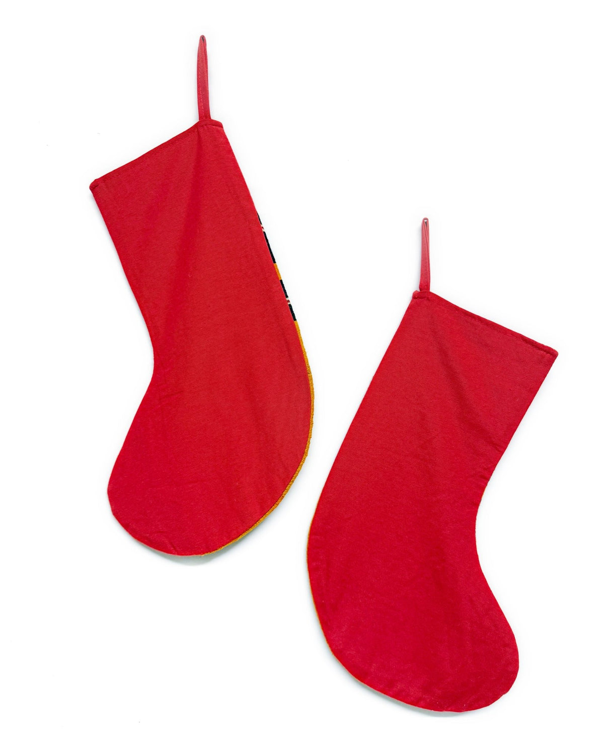 Two red Christmas stockings hanging against a plain white background.