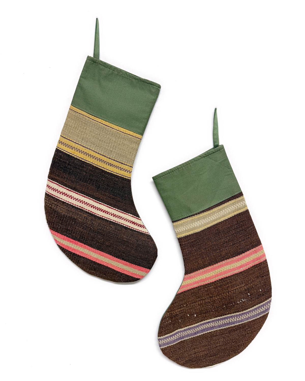 Two Turkish Kilim Christmas stockings with a rustic, handwoven striped pattern in olive green, brown, beige, pink, and purple, shown against a plain white background.
