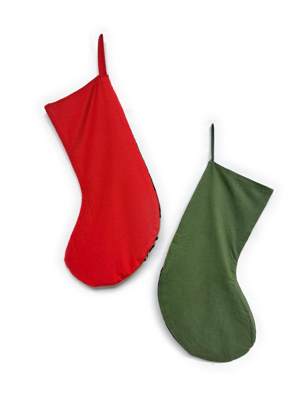 Two handwoven Turkish Kilim Christmas stockings. One stocking features a red cuff and red, orange, and beige stripes with a gold anchor motif.