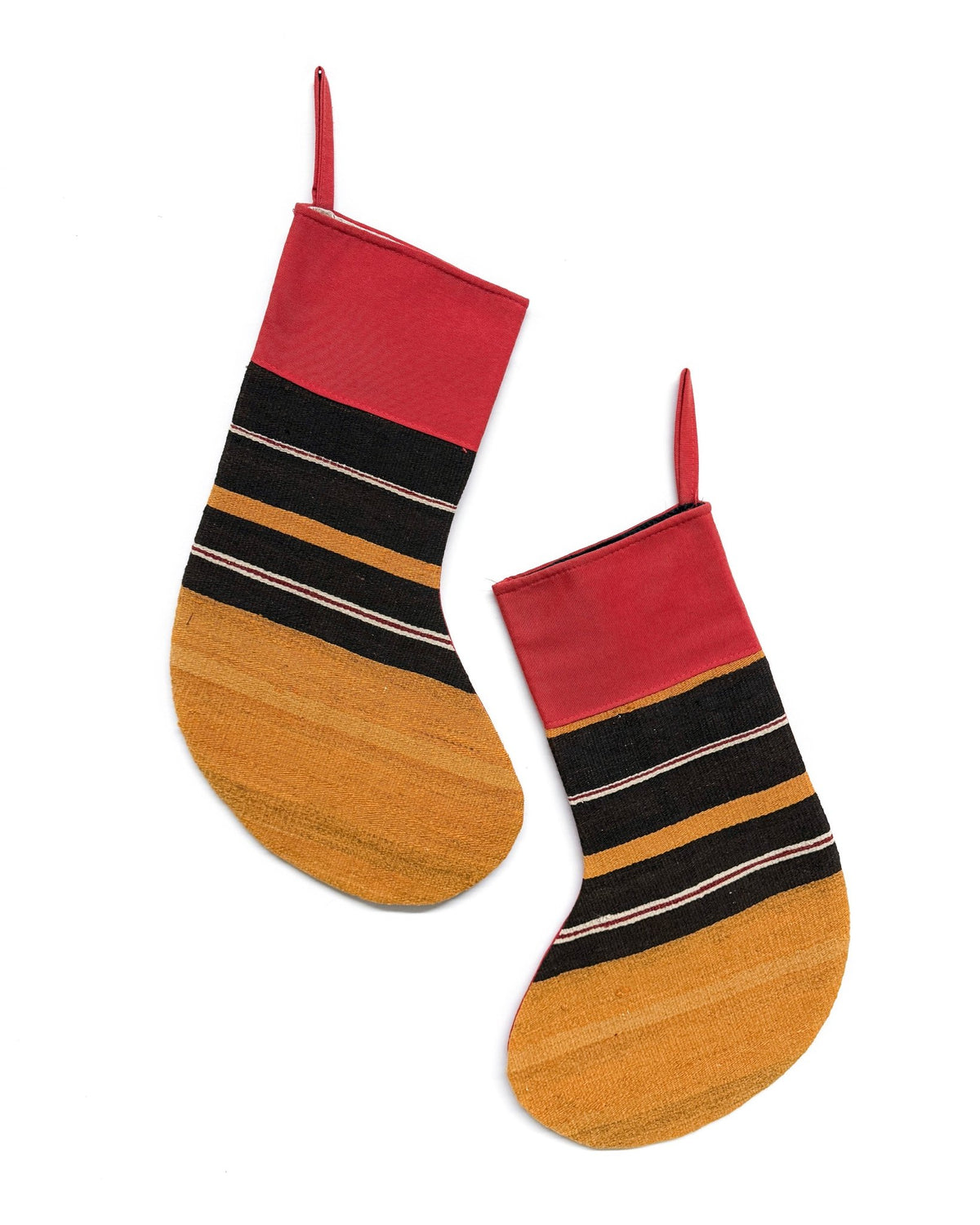 Two decorative Kilim Christmas stockings with a woven pattern, featuring a red top, black and tan horizontal stripes, and a golden-yellow textured bottom, shown against a plain white background.