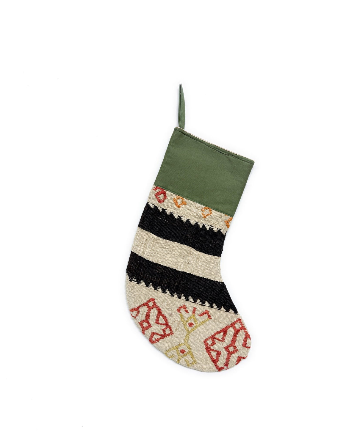 A single Kilim Christmas stocking with a green cuff and a patterned body featuring horizontal black and cream stripes, red geometric motifs, and small yellow accents, shown against a plain white background.