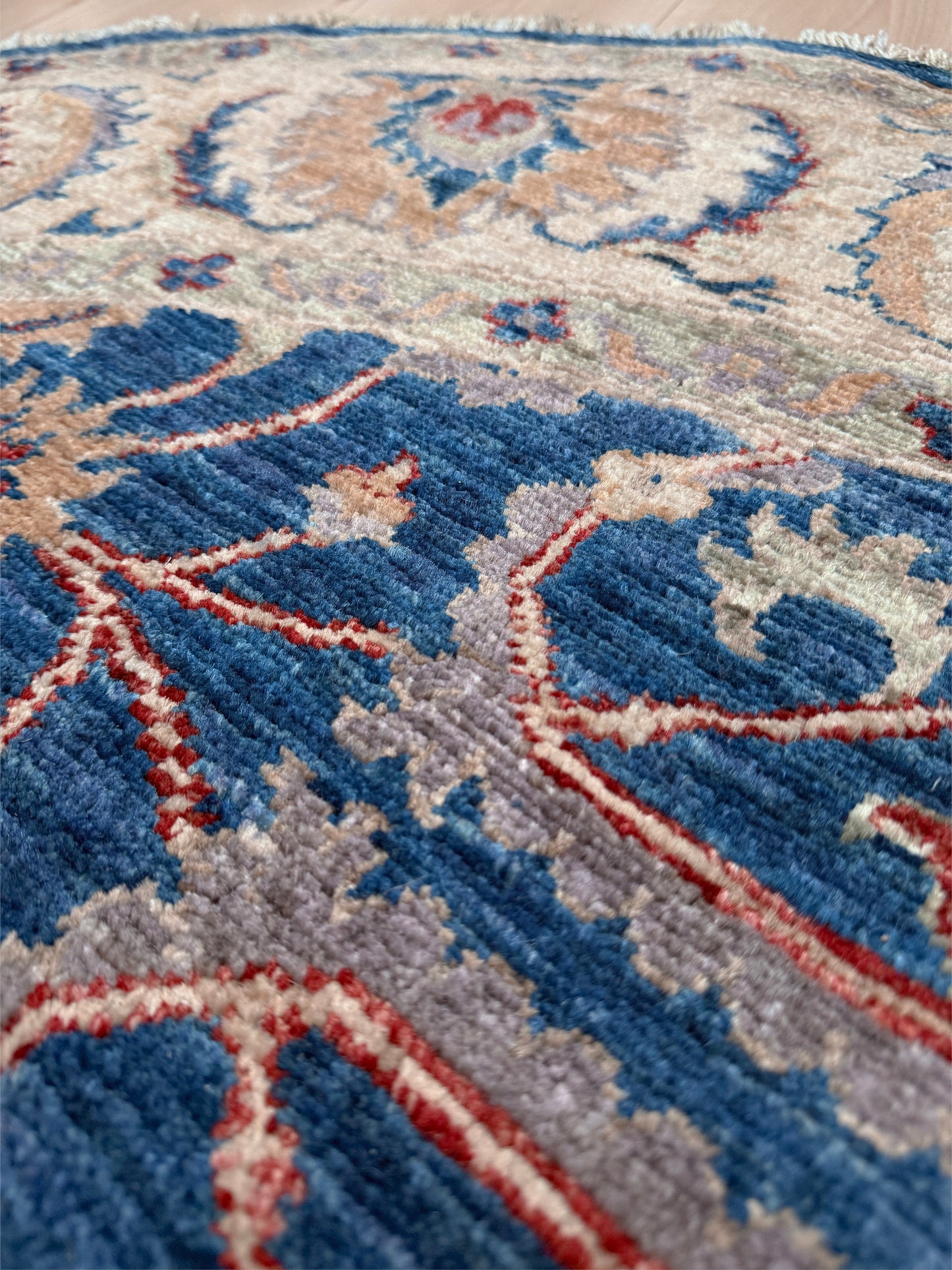 Round Oushak rug with blue field, beige border, muted gold, dusty red floral details, handmade wool 6x6 round area rug from Indigo Rugs Burlingame Bay Area.