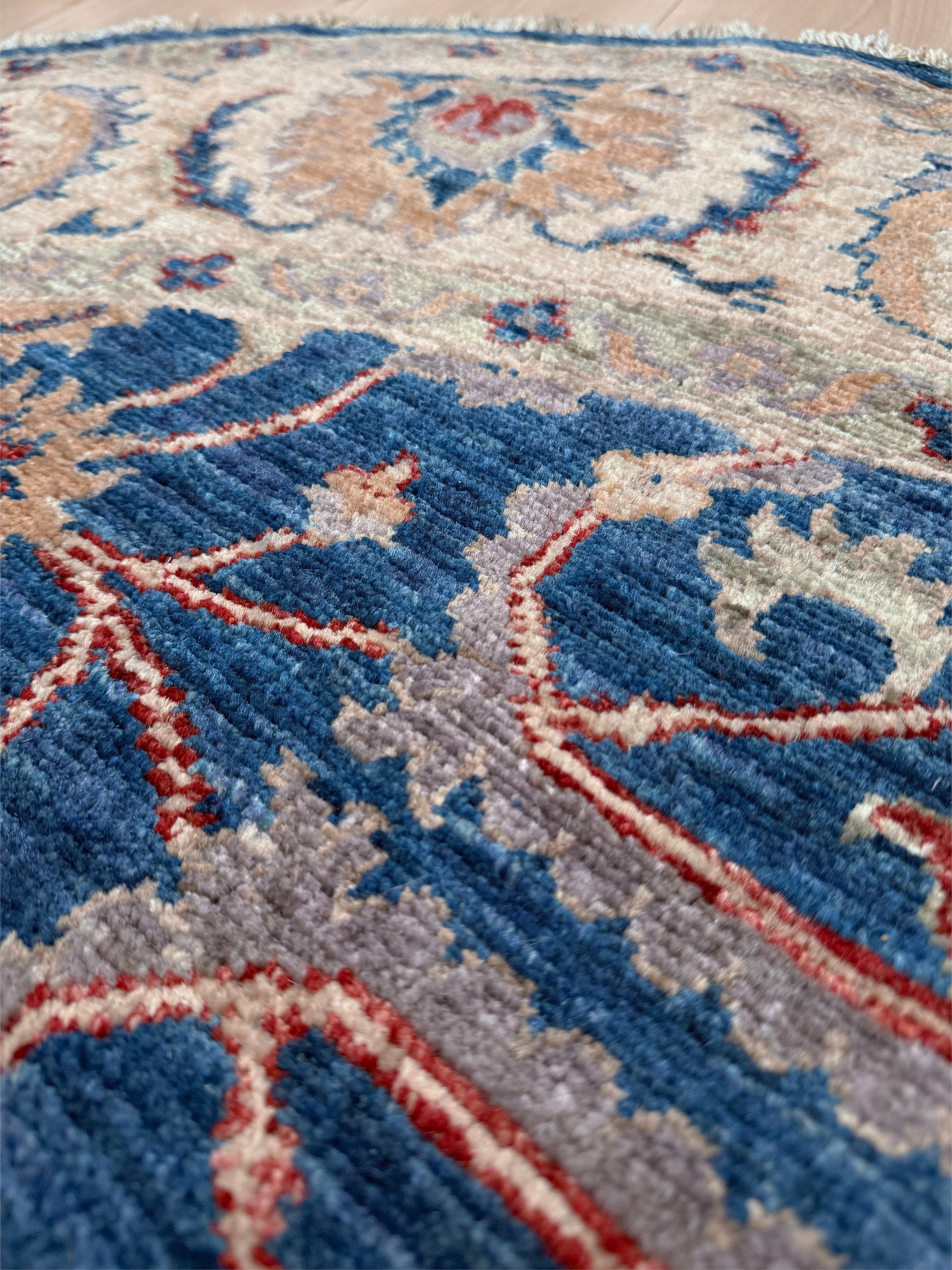 Round Oushak rug with blue field, beige border, muted gold, dusty red floral details, handmade wool 6x6 round area rug from Indigo Rugs Burlingame Bay Area.
