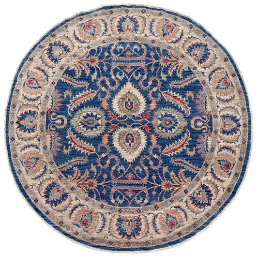 Round decorative rug with intricate paisley pattern on a white background. Round Oushak rug with blue field, beige border, muted gold, dusty red floral details, handmade wool 6x6 round area rug from Indigo Rugs Burlingame Bay Area.