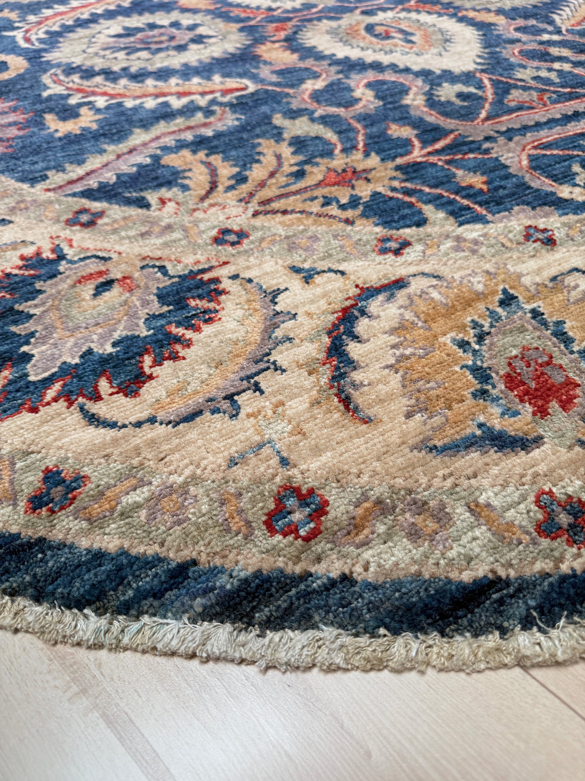 Round Oushak rug with blue field, beige border, muted gold, dusty red floral details, handmade wool 6x6 round area rug from Indigo Rugs Burlingame Bay Area.