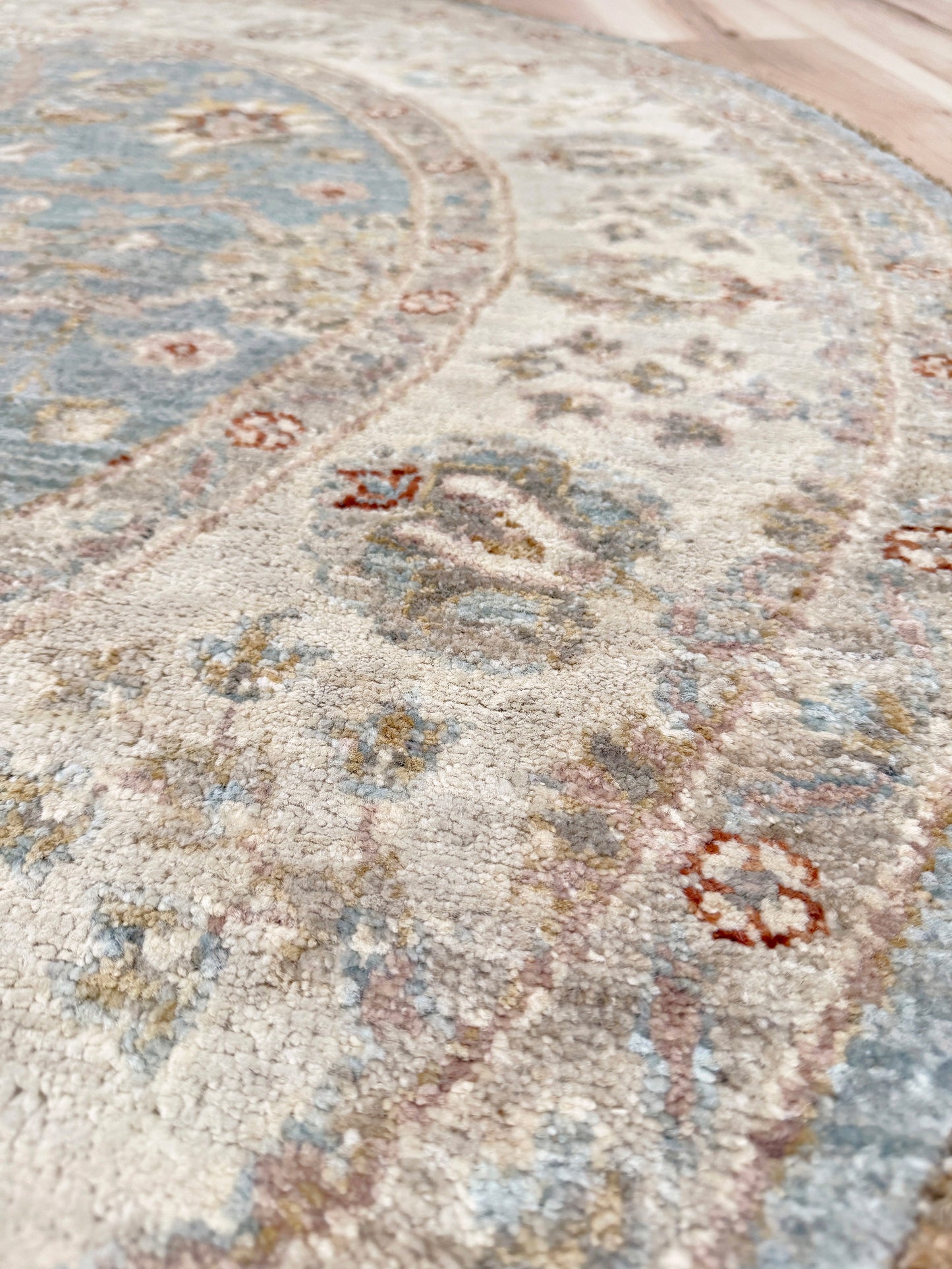 Pale blue round Turkish Oushak rug with soft colored floral details, handmade wool 5x5 round area rug from Indigo Rugs Burlingame Bay Area.