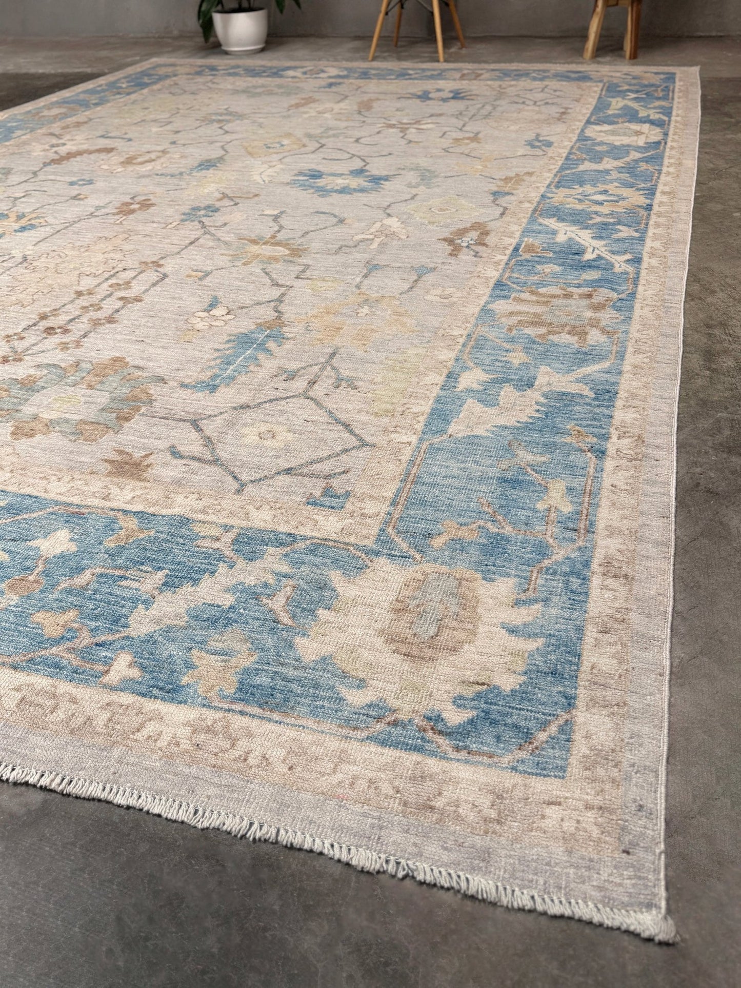 Brand new Turkish Oushak rug with soft ivory field, pale blue border, faded floral motifs, handmade wool area rug 9x12 from Indigo Rugs Burlingame Bay Area.