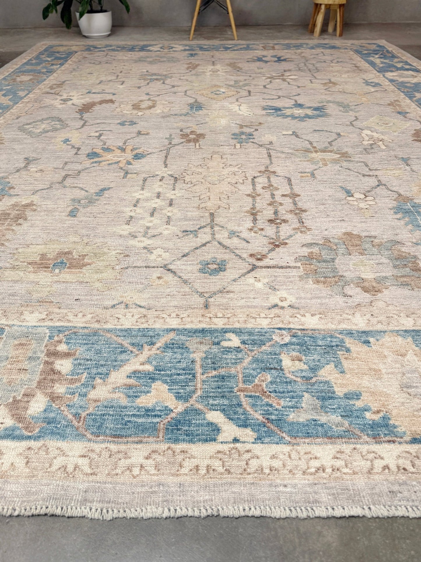 Brand new Turkish Oushak rug with soft ivory field, pale blue border, faded floral motifs, handmade wool area rug 9x12 from Indigo Rugs Burlingame Bay Area.