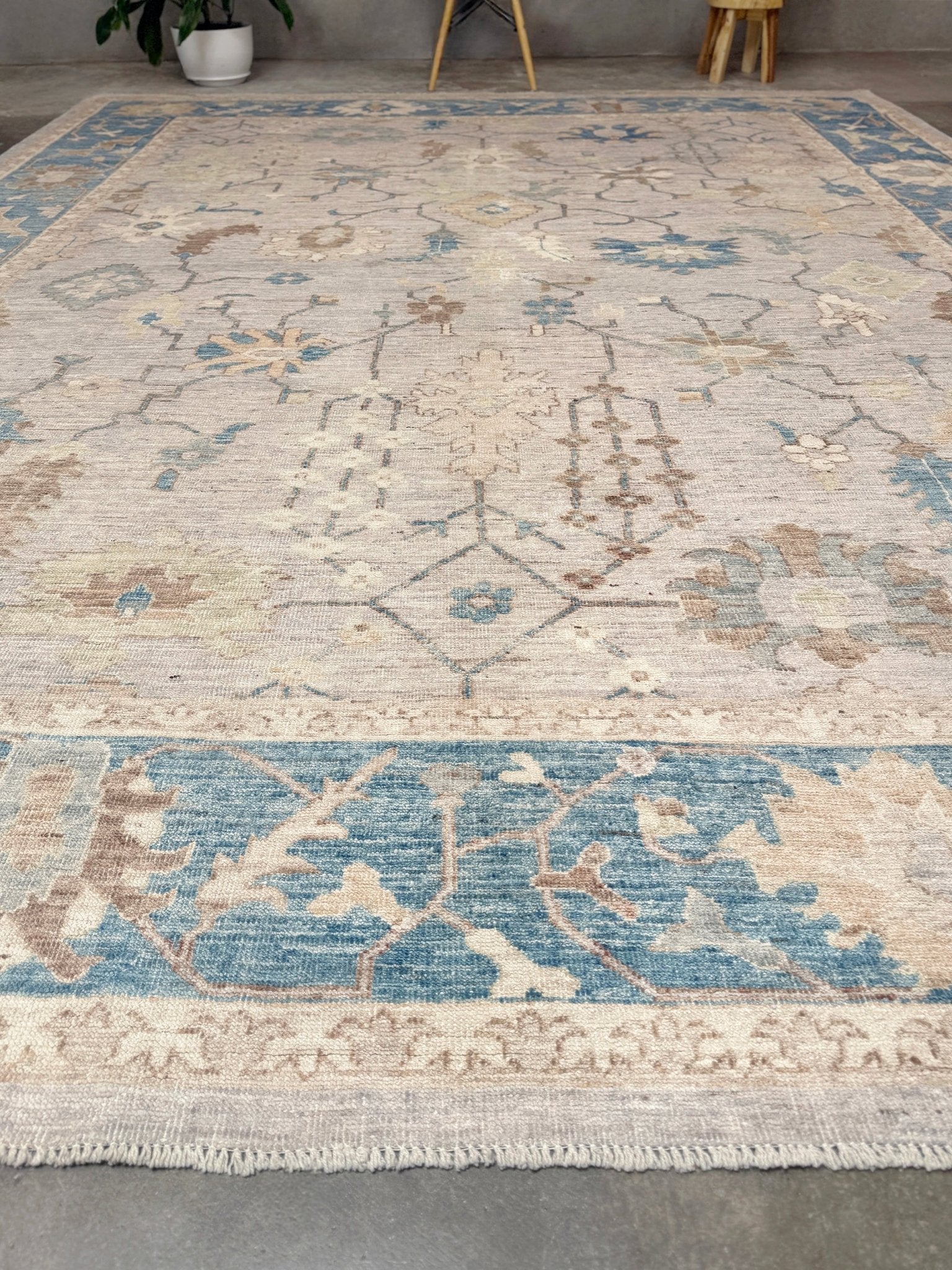 Brand new Turkish Oushak rug with soft ivory field, pale blue border, faded floral motifs, handmade wool area rug 9x12 from Indigo Rugs Burlingame Bay Area.
