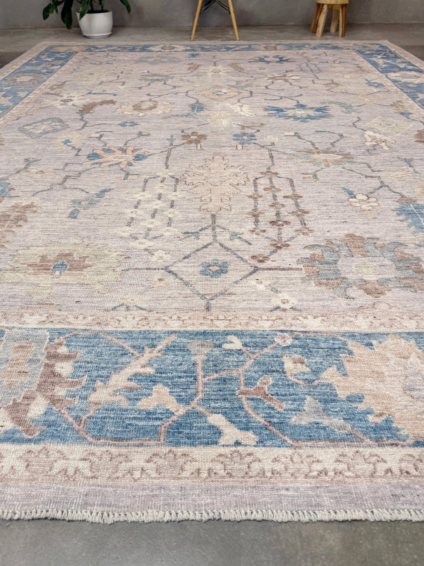 Brand new Turkish Oushak rug with soft ivory field, pale blue border, faded floral motifs, handmade wool area rug 9x12 from Indigo Rugs Burlingame Bay Area.