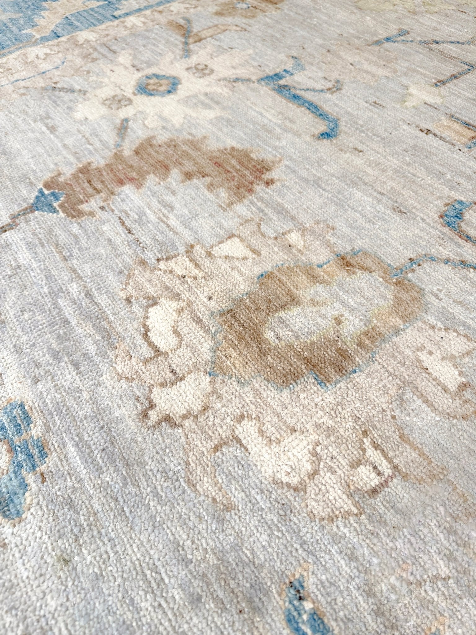 Brand new Turkish Oushak rug with soft ivory field, pale blue border, faded floral motifs, handmade wool area rug 9x12 from Indigo Rugs Burlingame Bay Area.