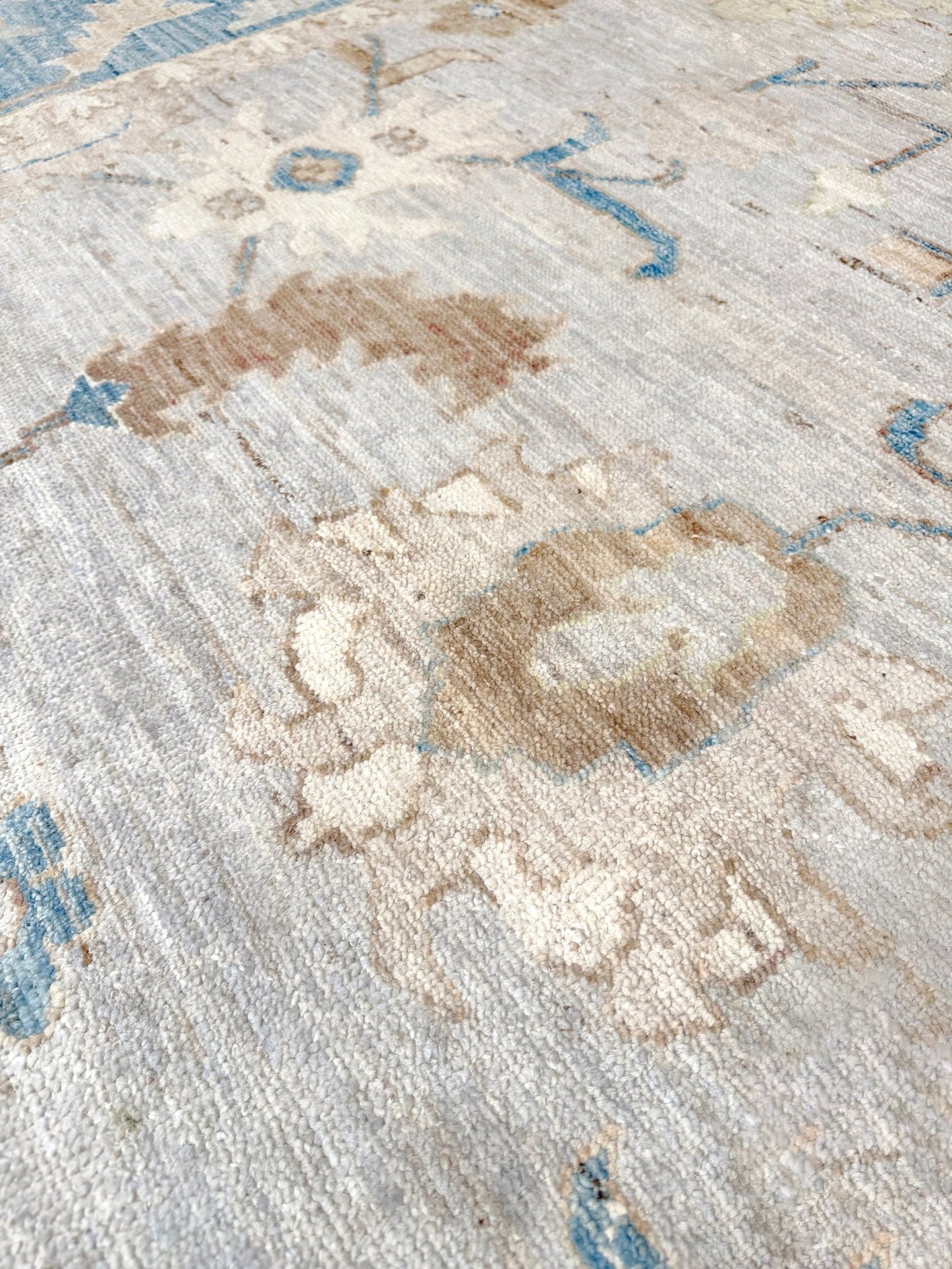 Brand new Turkish Oushak rug with soft ivory field, pale blue border, faded floral motifs, handmade wool area rug 9x12 from Indigo Rugs Burlingame Bay Area.