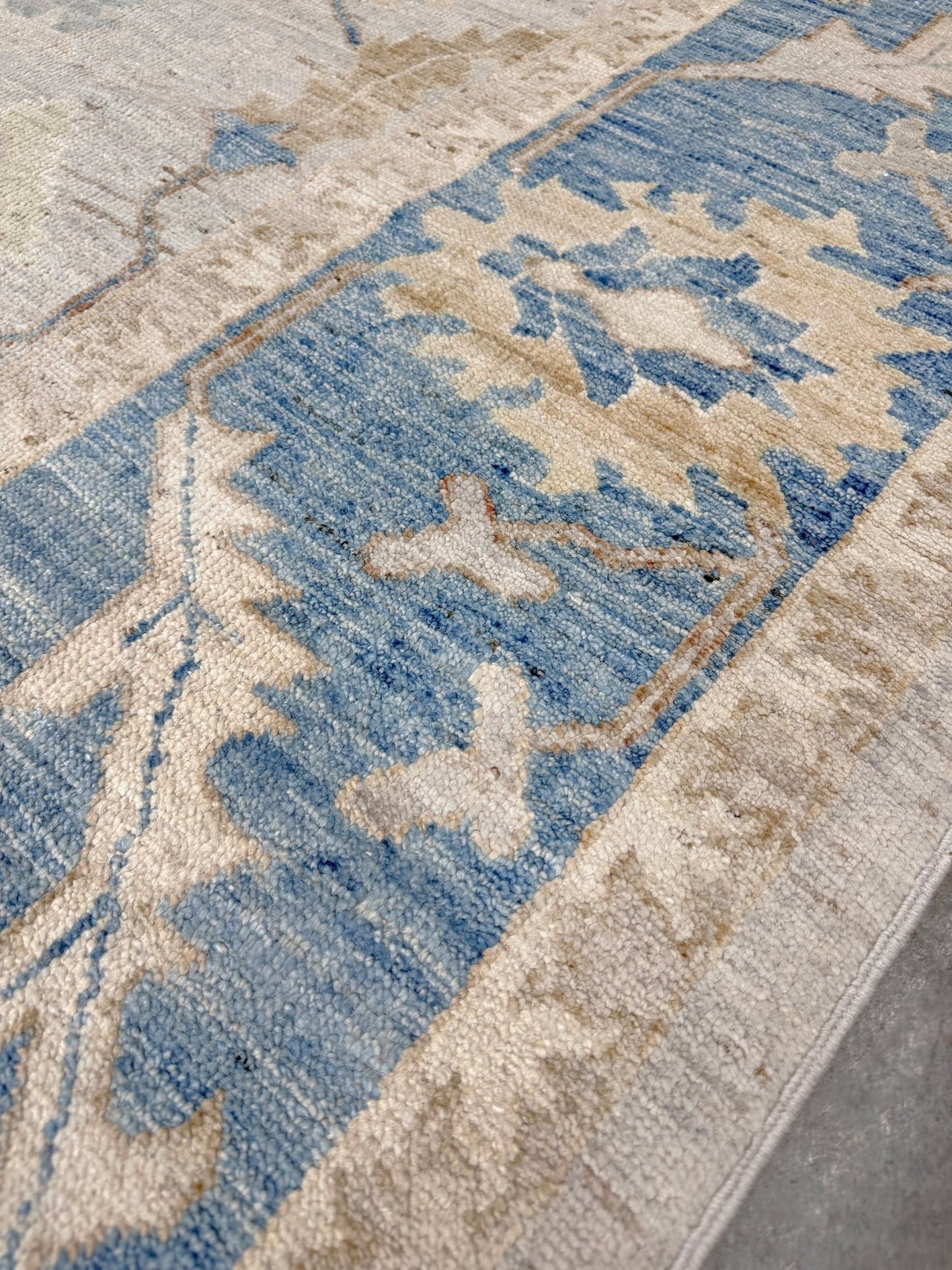 Brand new Turkish Oushak rug with soft ivory field, pale blue border, faded floral motifs, handmade wool area rug 9x12 from Indigo Rugs Burlingame Bay Area.
