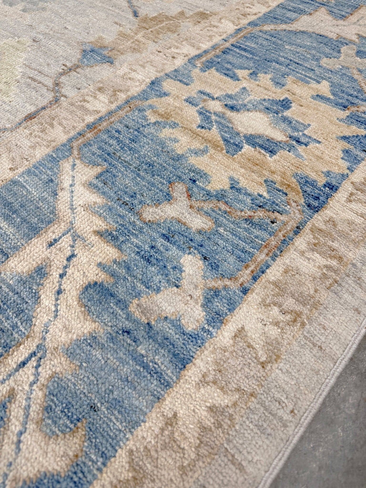 Brand new Turkish Oushak rug with soft ivory field, pale blue border, faded floral motifs, handmade wool area rug 9x12 from Indigo Rugs Burlingame Bay Area.