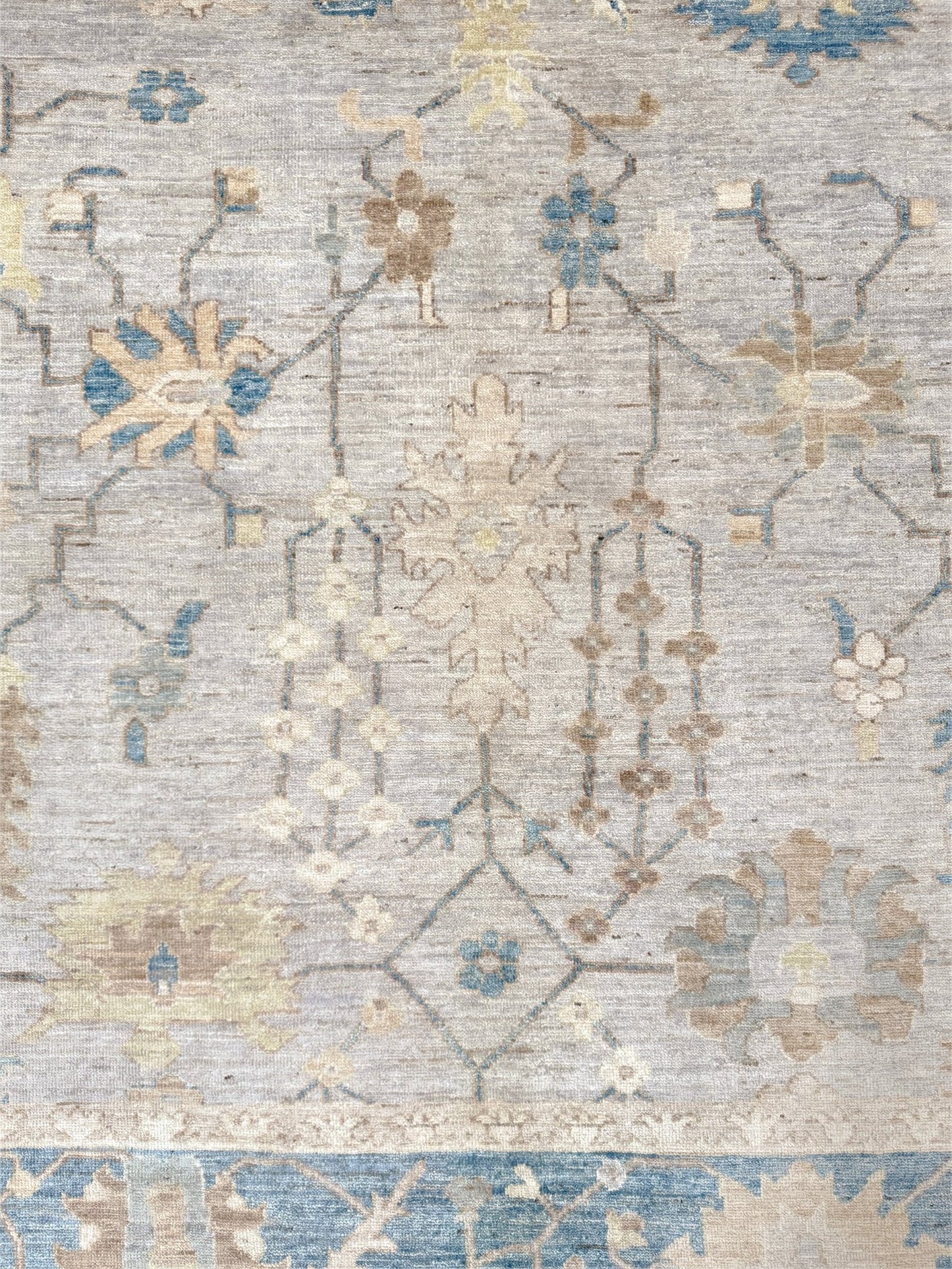 Brand new Turkish Oushak rug with soft ivory field, pale blue border, faded floral motifs, handmade wool area rug 9x12 from Indigo Rugs Burlingame Bay Area.