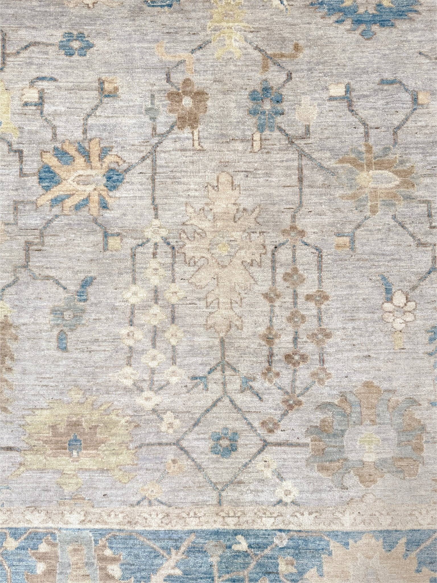 Brand new Turkish Oushak rug with soft ivory field, pale blue border, faded floral motifs, handmade wool area rug 9x12 from Indigo Rugs Burlingame Bay Area.