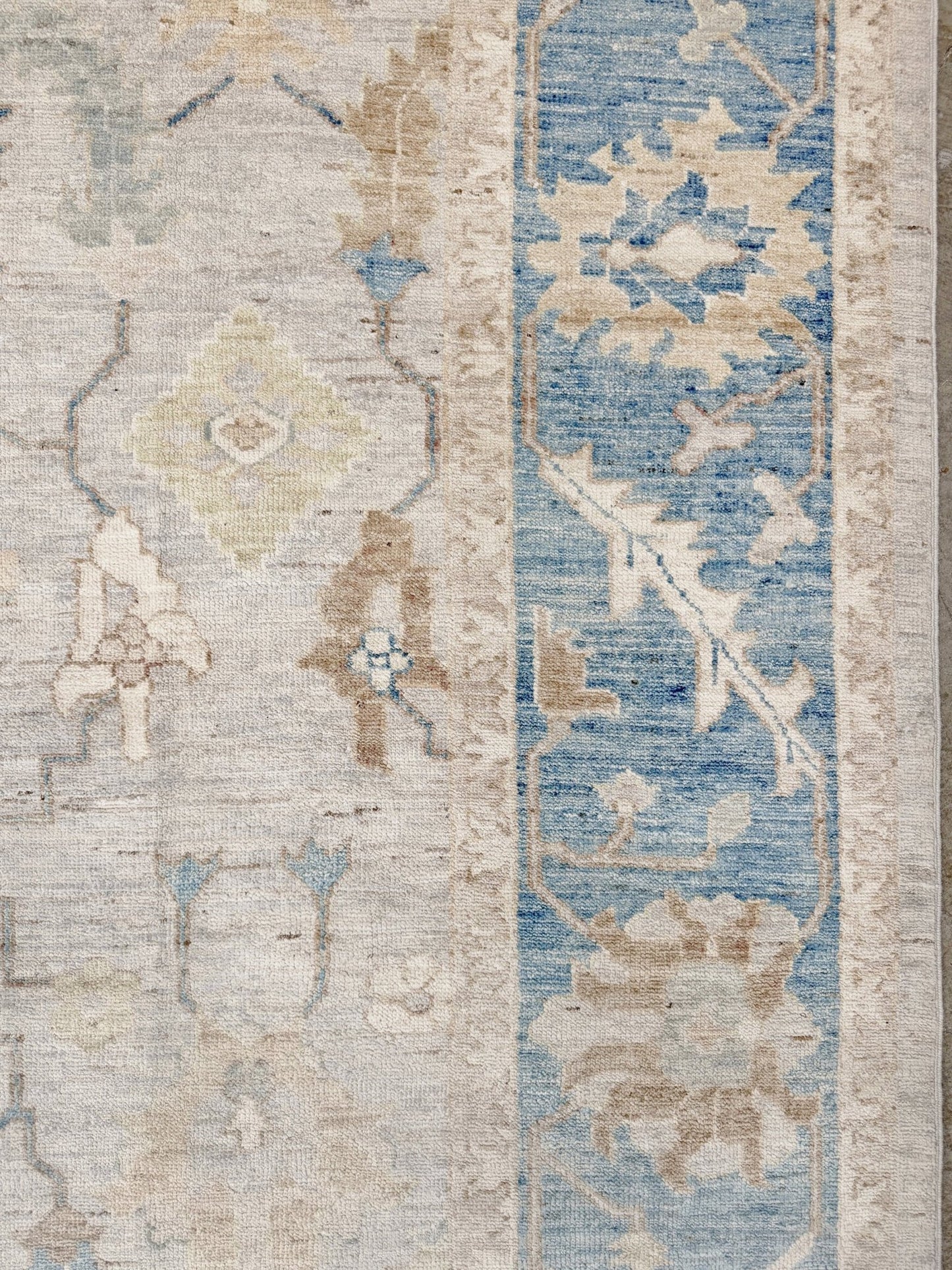 Brand new Turkish Oushak rug with soft ivory field, pale blue border, faded floral motifs, handmade wool area rug 9x12 from Indigo Rugs Burlingame Bay Area.