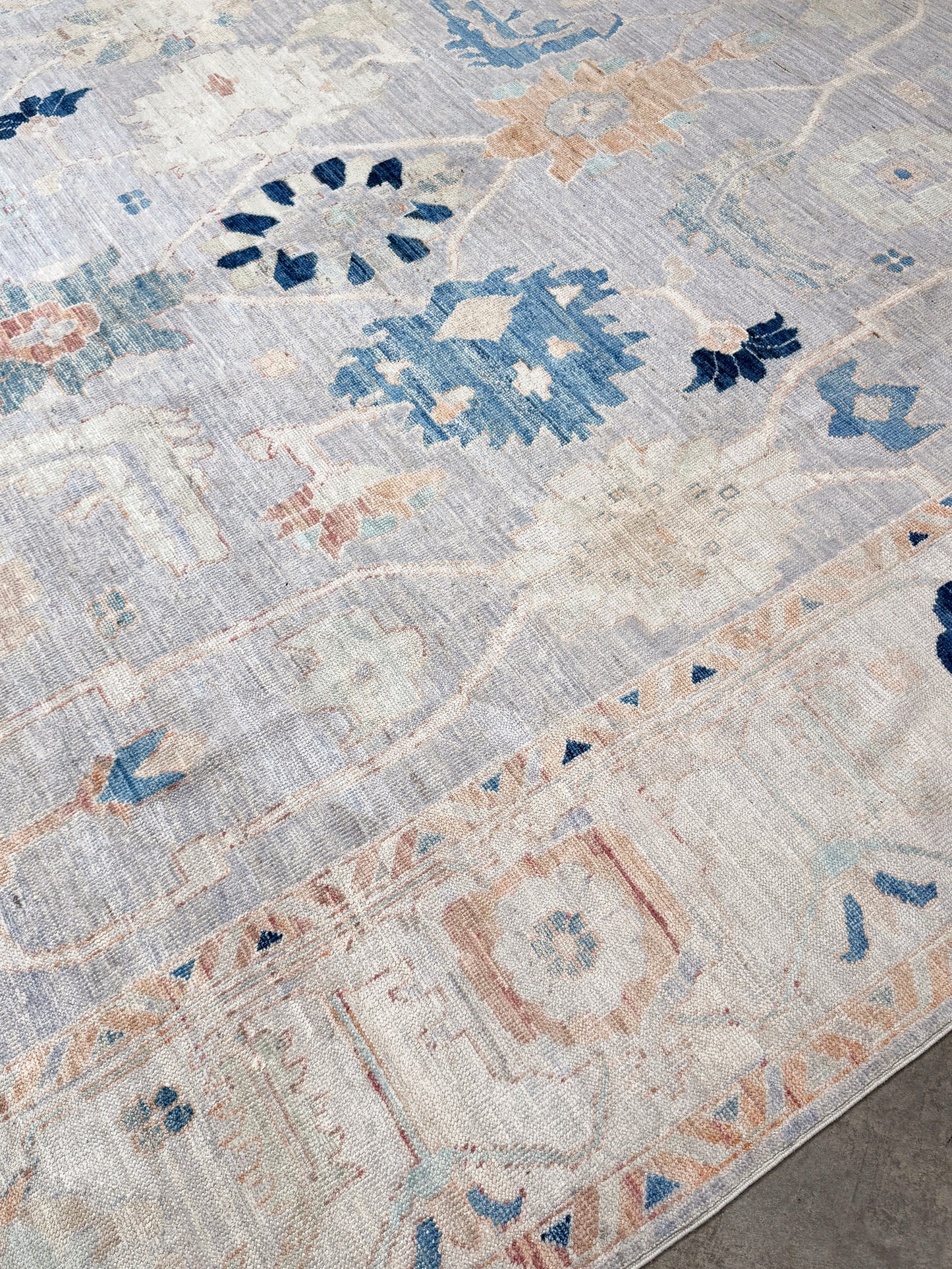Brand new Turkish Oushak rug with pale blue field, subtle lilac undertones, soft ivory border, faded blue and peach beige accents, handmade wool area rug 9x12 from Indigo Rugs Burlingame Bay Area.