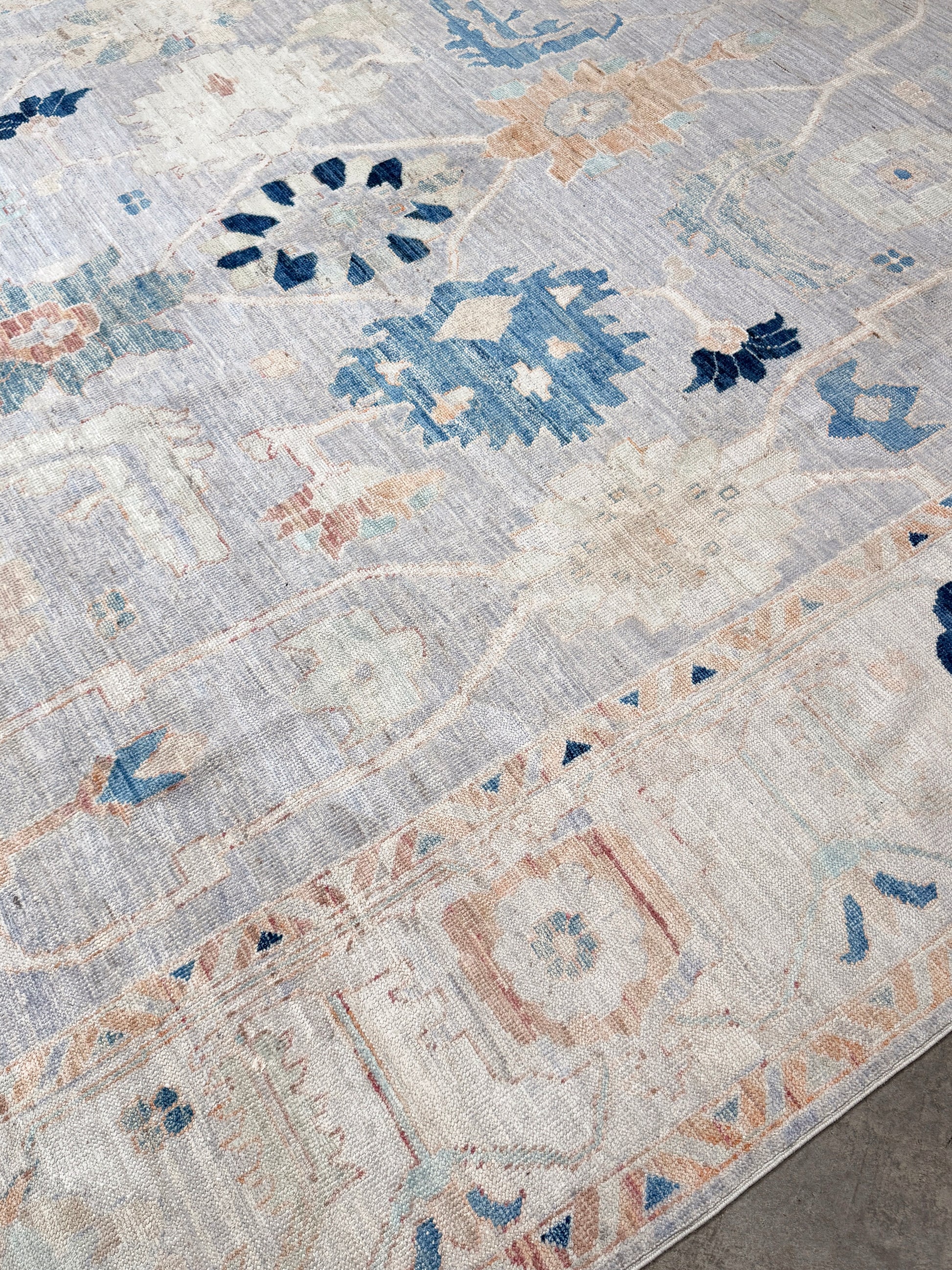 Brand new Turkish Oushak rug with pale blue field, subtle lilac undertones, soft ivory border, faded blue and peach beige accents, handmade wool area rug 9x12 from Indigo Rugs Burlingame Bay Area.