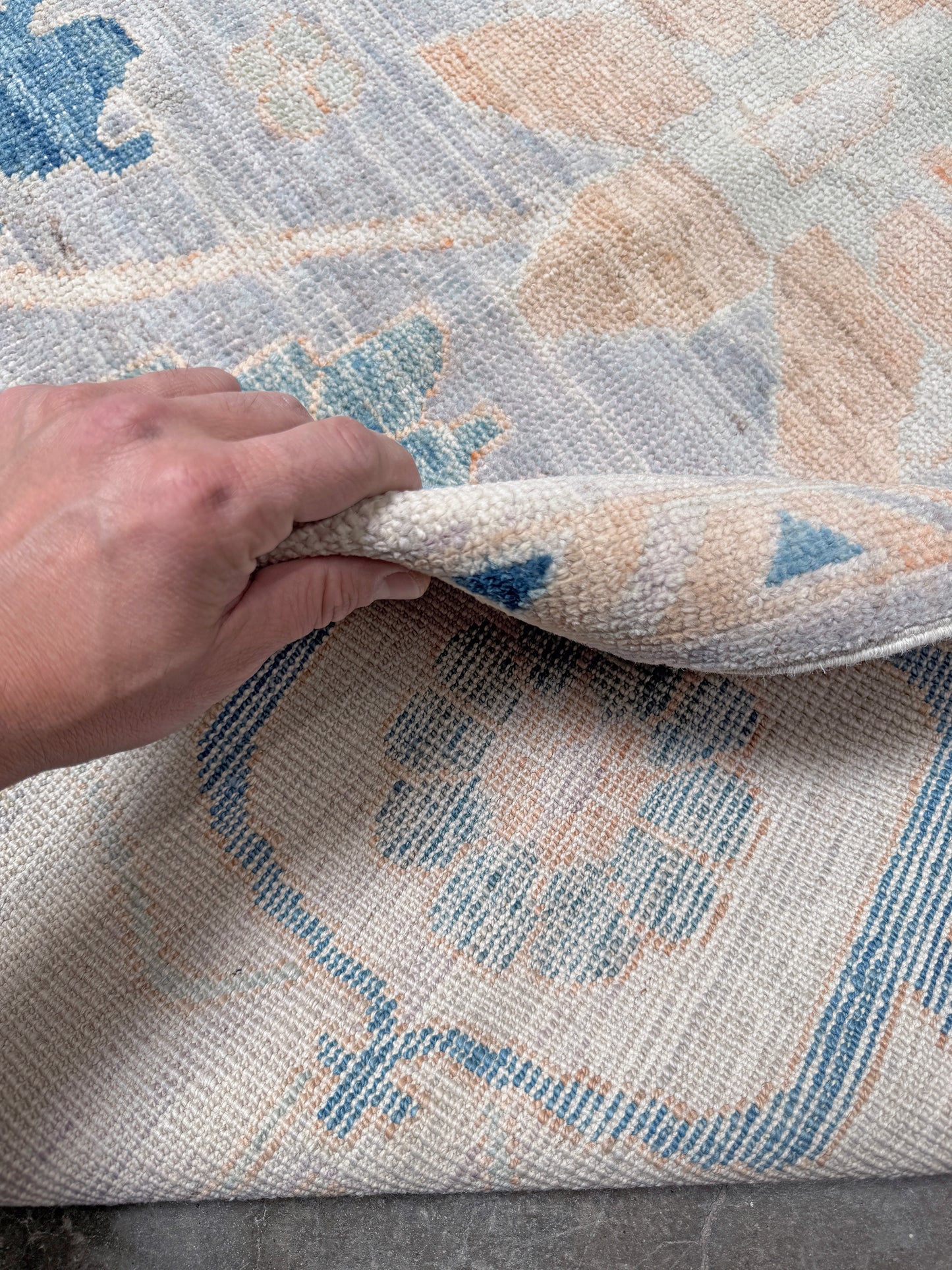 Brand new Turkish Oushak rug with pale blue field, subtle lilac undertones, soft ivory border, faded blue and peach beige accents, handmade wool area rug 9x12 from Indigo Rugs Burlingame Bay Area.