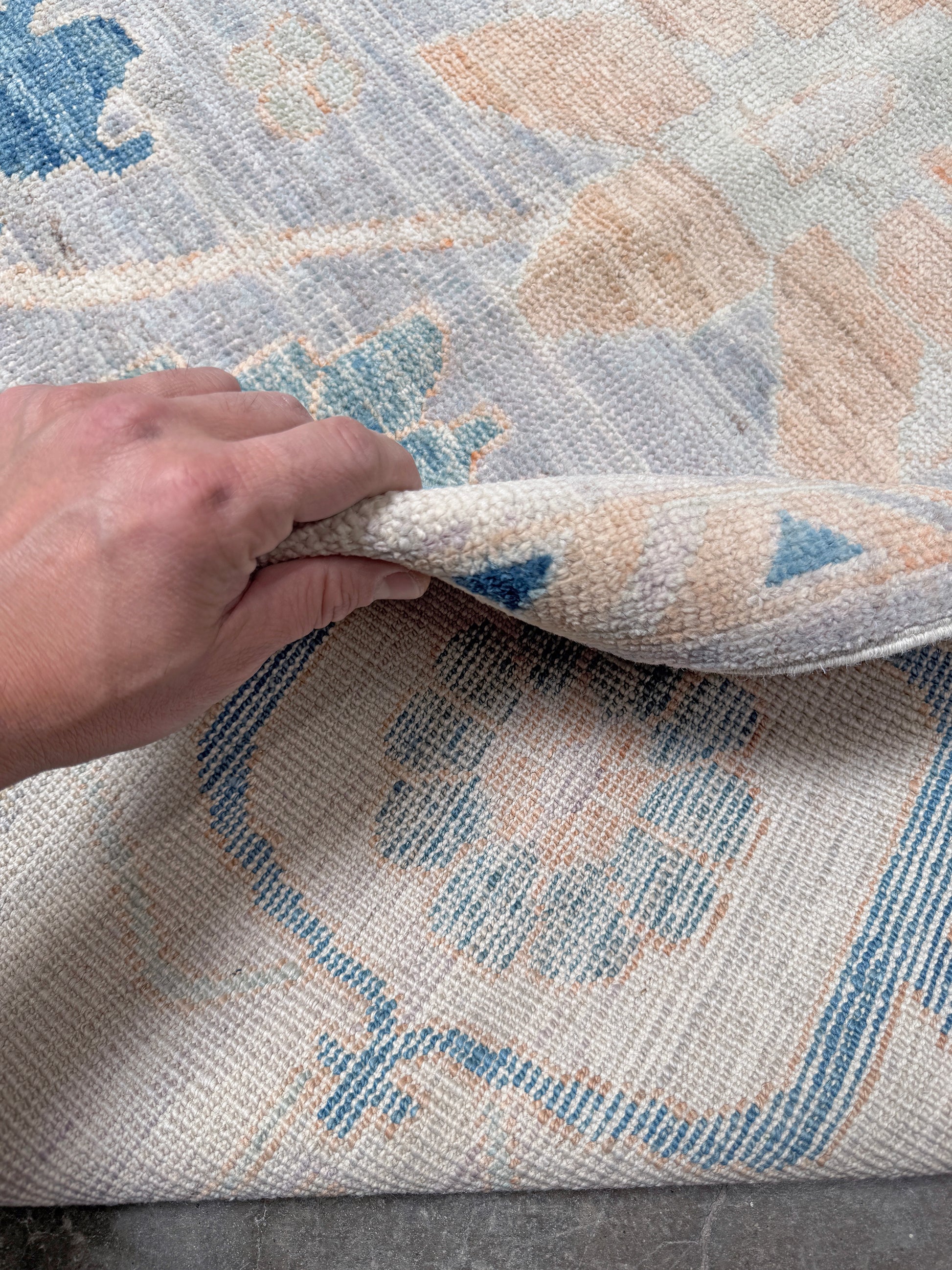Brand new Turkish Oushak rug with pale blue field, subtle lilac undertones, soft ivory border, faded blue and peach beige accents, handmade wool area rug 9x12 from Indigo Rugs Burlingame Bay Area.