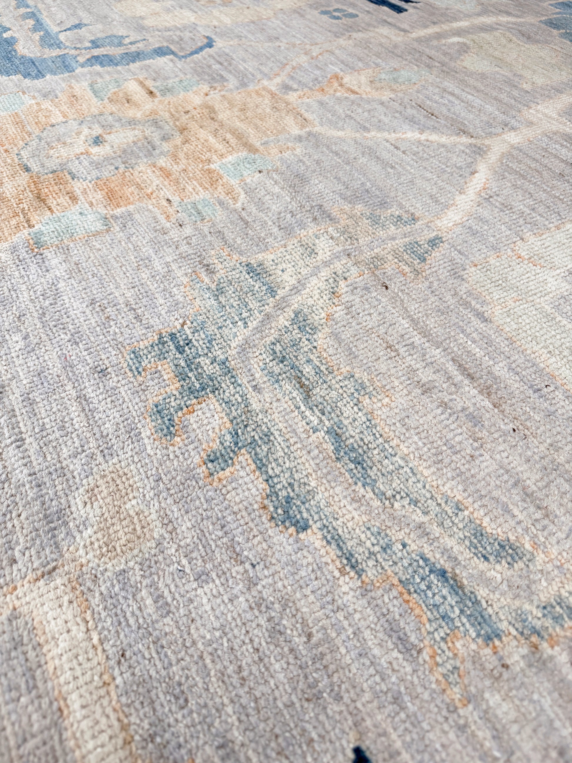 Brand new Turkish Oushak rug with pale blue field, subtle lilac undertones, soft ivory border, faded blue and peach beige accents, handmade wool area rug 9x12 from Indigo Rugs Burlingame Bay Area.