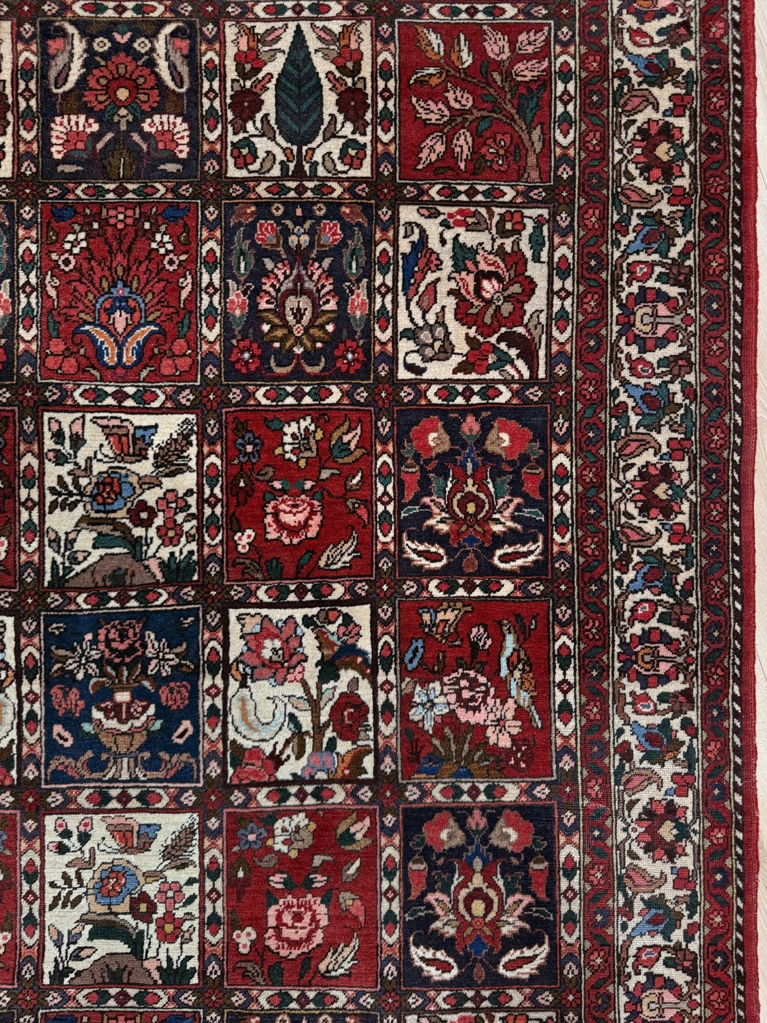 Vintage Persian Bakhtiari rug wit red field, navy garden panels, ivory details, and intricate floral motifs, handmade wool area rug 5x8 from Indigo Rugs Burlingame SF Bay Area