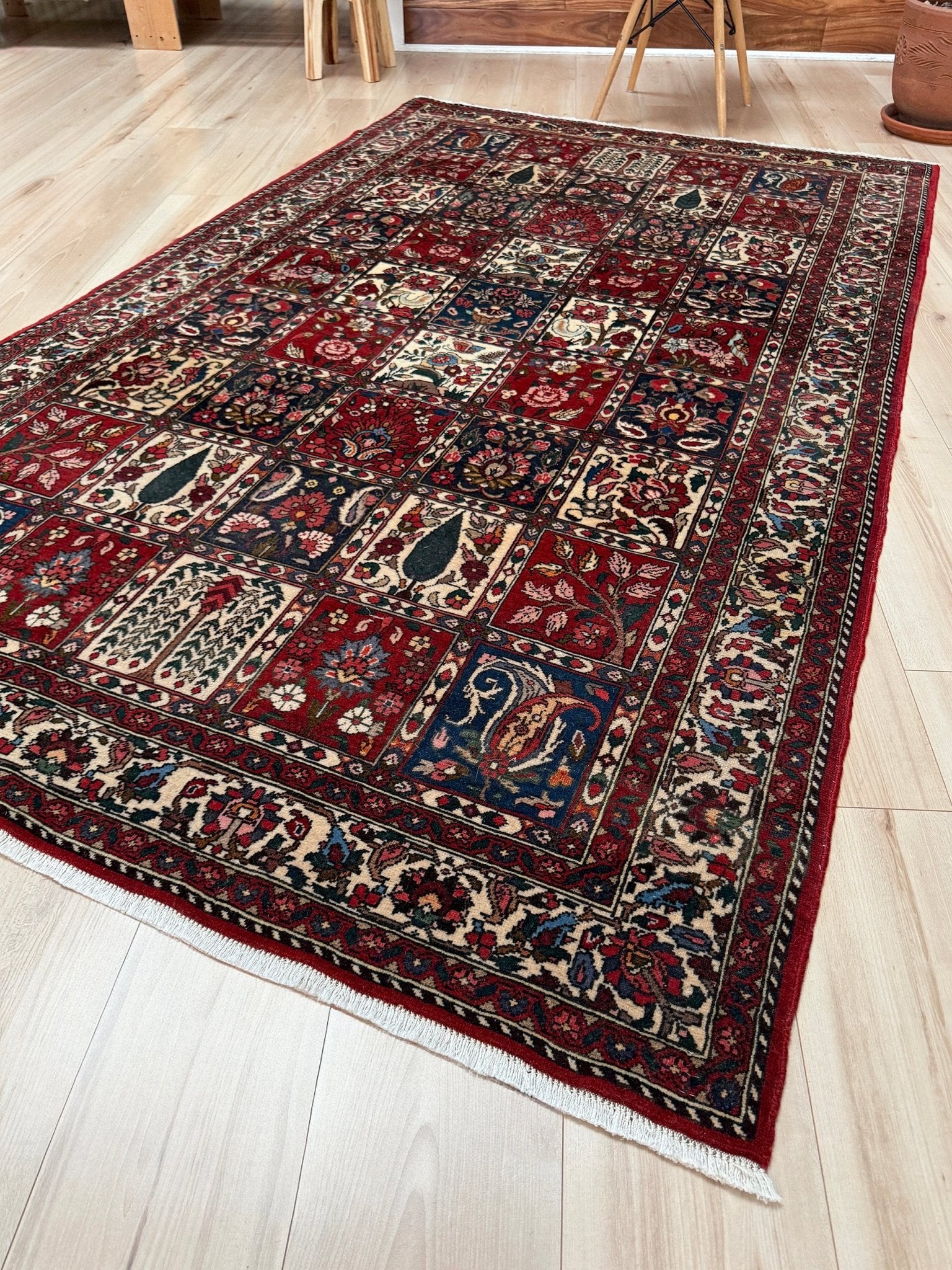 Vintage Persian Bakhtiari rug wit red field, navy garden panels, ivory details, and intricate floral motifs, handmade wool area rug 5x8 from Indigo Rugs Burlingame SF Bay Area