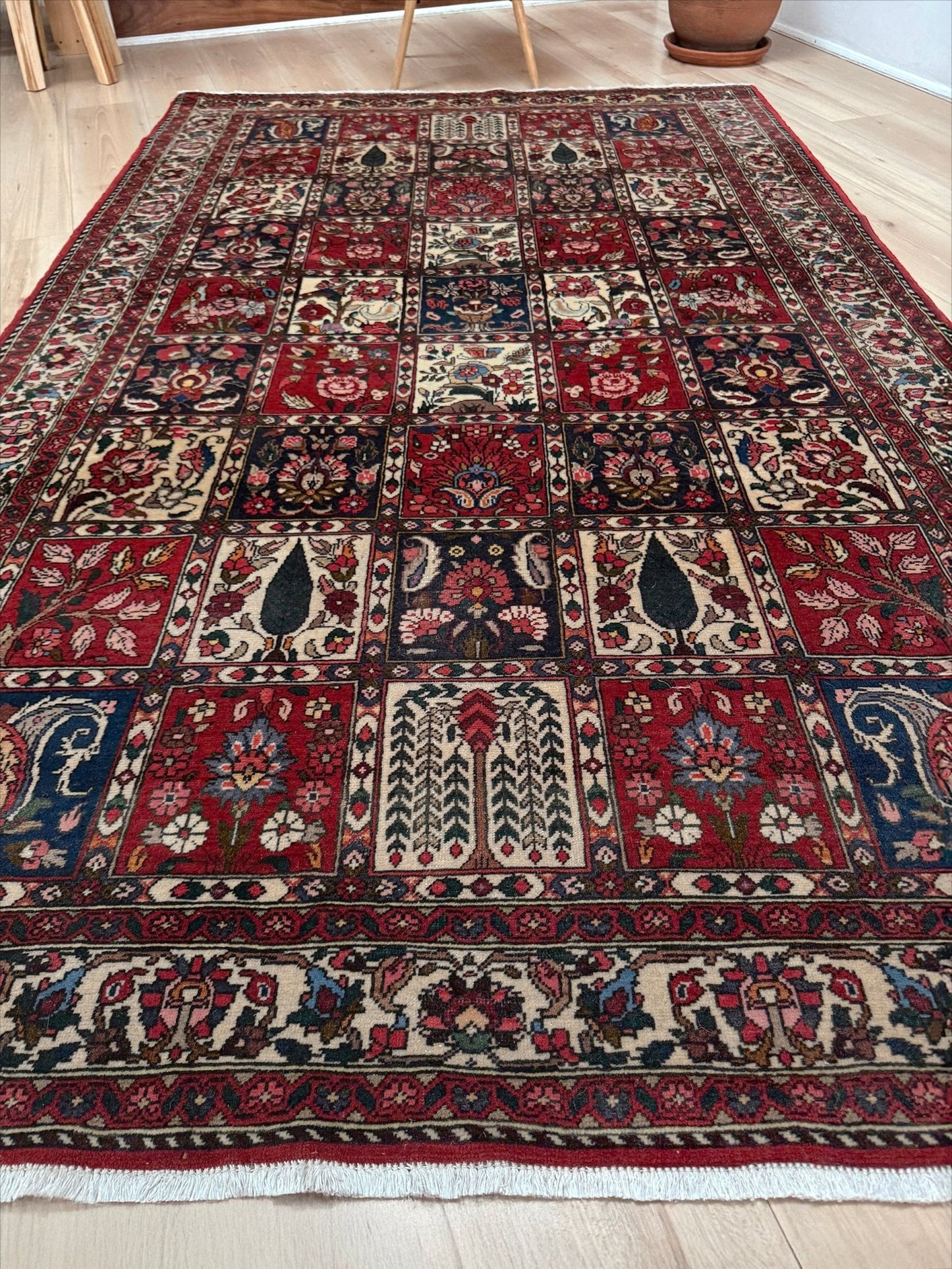 Vintage Persian Bakhtiari rug wit red field, navy garden panels, ivory details, and intricate floral motifs, handmade wool area rug 5x8 from Indigo Rugs Burlingame SF Bay Area