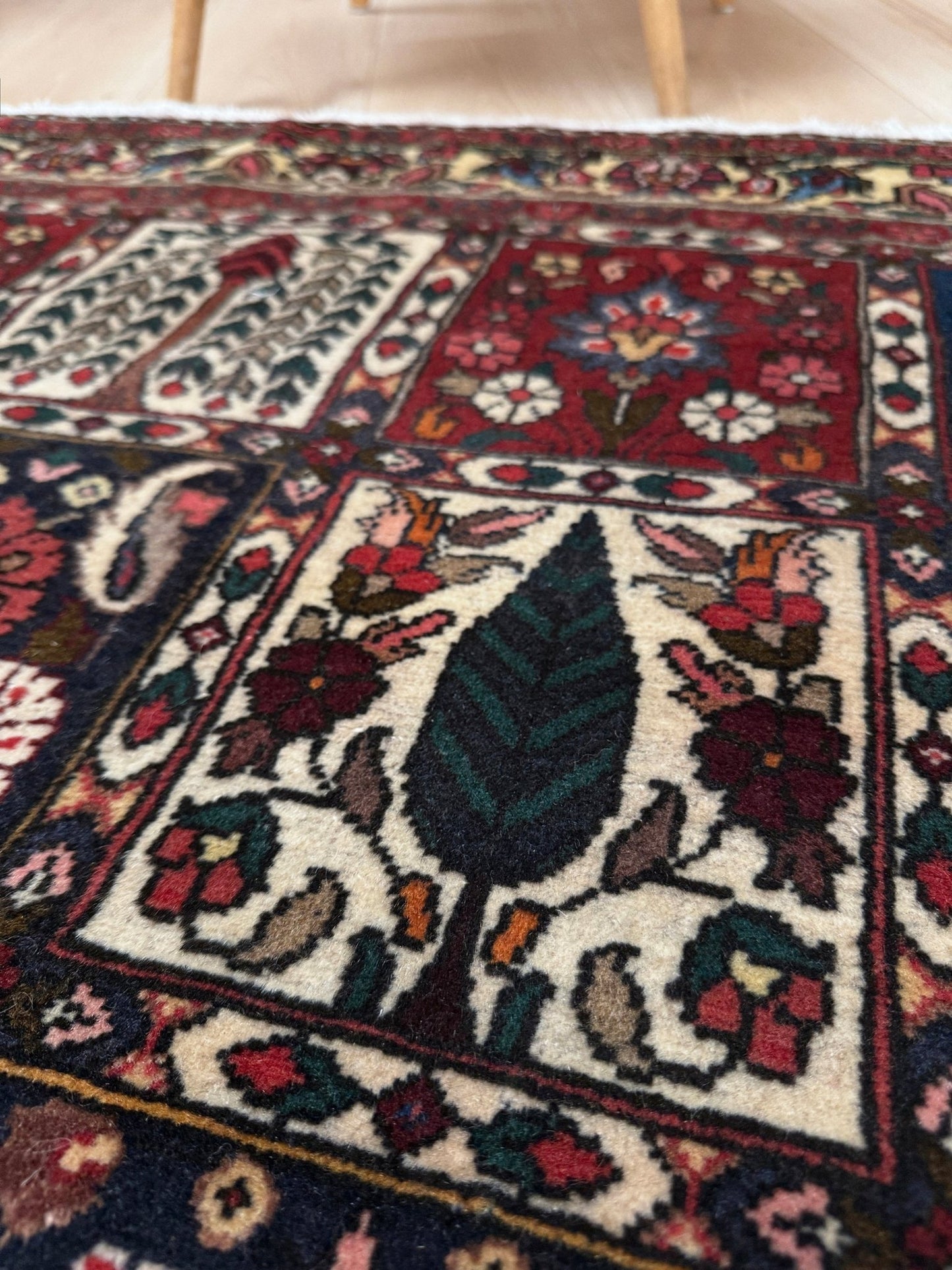 Vintage Persian Bakhtiari rug wit red field, navy garden panels, ivory details, and intricate floral motifs, handmade wool area rug 5x8 from Indigo Rugs Burlingame SF Bay Area