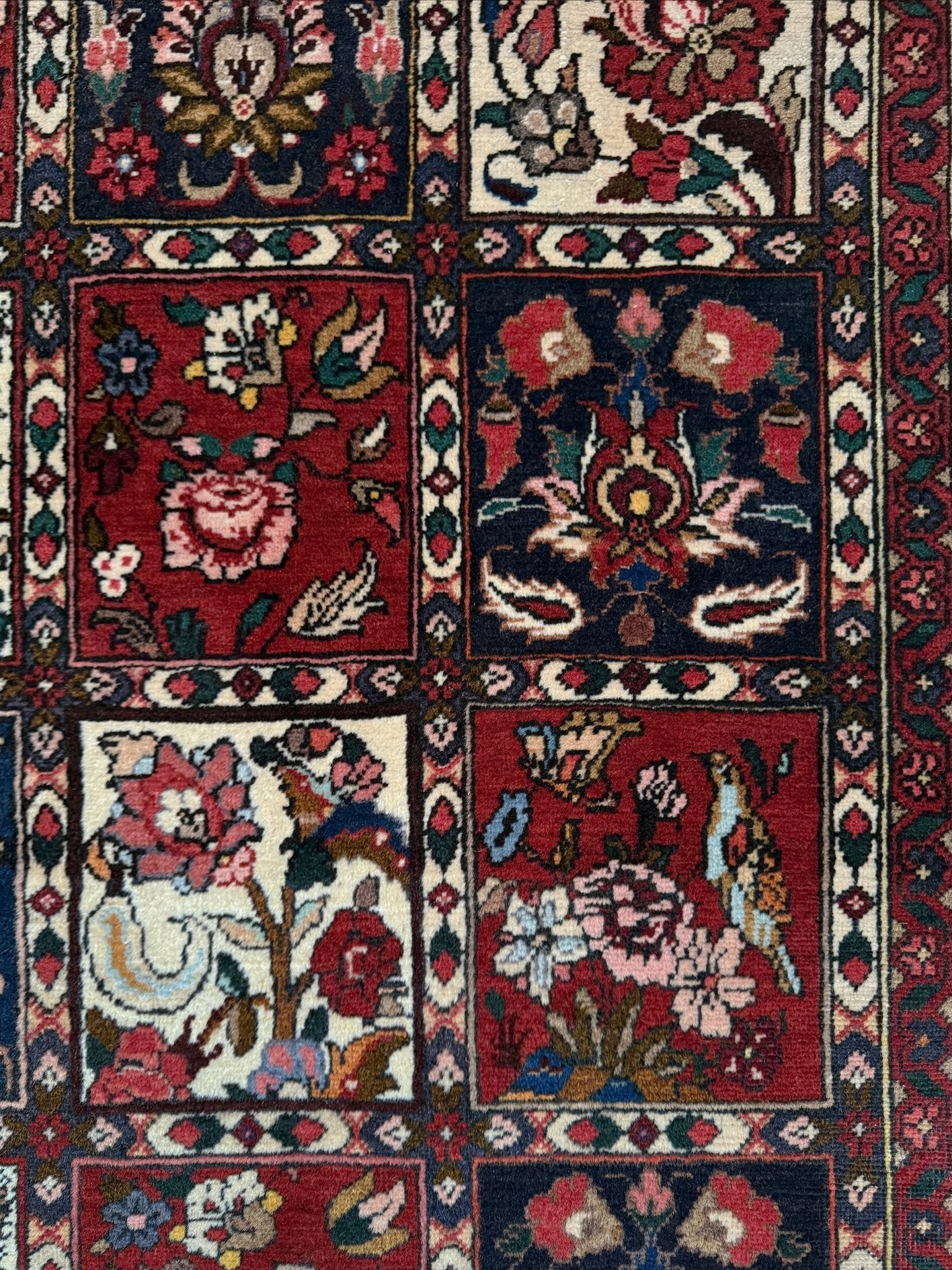 Vintage Persian Bakhtiari rug wit red field, navy garden panels, ivory details, and intricate floral motifs, handmade wool area rug 5x8 from Indigo Rugs Burlingame SF Bay Area
