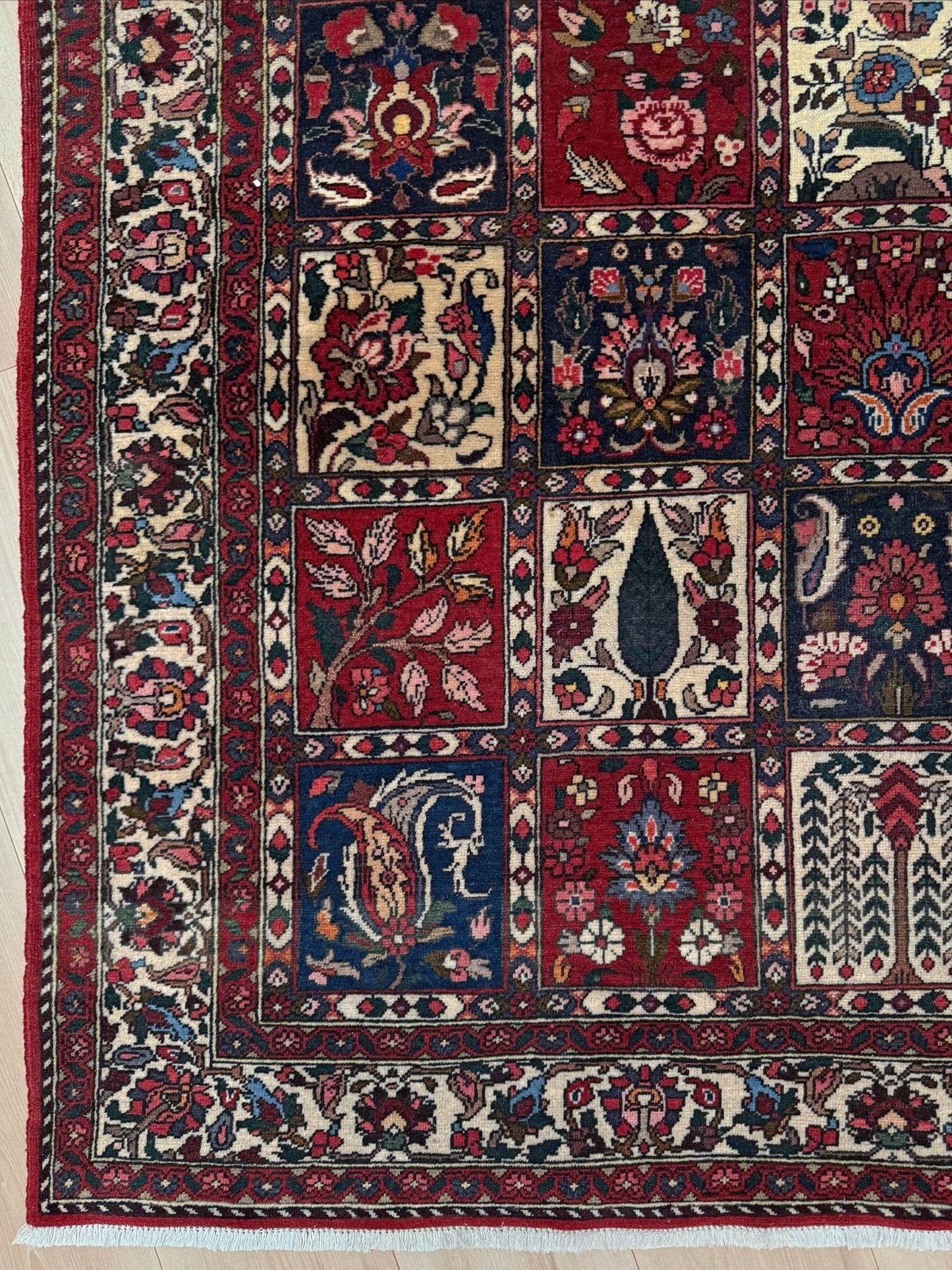 Vintage Persian Bakhtiari rug wit red field, navy garden panels, ivory details, and intricate floral motifs, handmade wool area rug 5x8 from Indigo Rugs Burlingame SF Bay Area