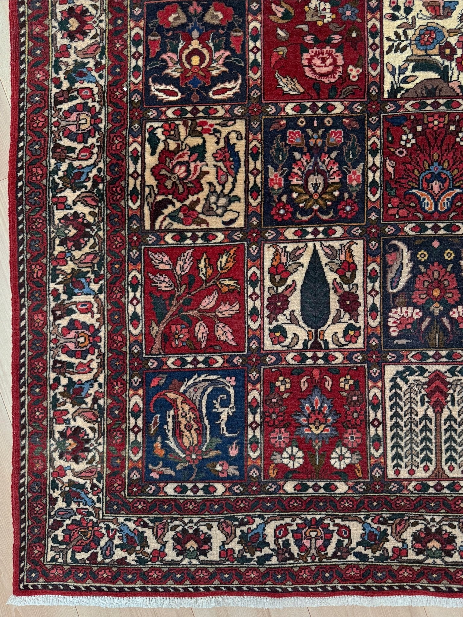 Vintage Persian Bakhtiari rug wit red field, navy garden panels, ivory details, and intricate floral motifs, handmade wool area rug 5x8 from Indigo Rugs Burlingame SF Bay Area