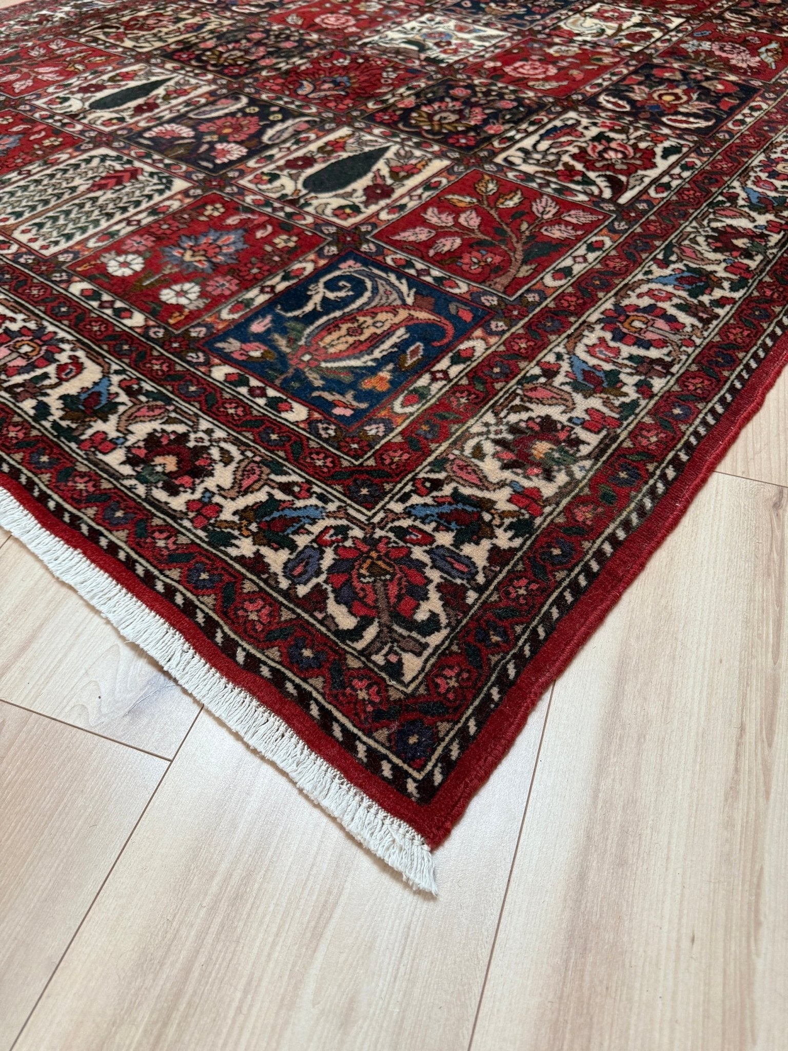Vintage Persian Bakhtiari rug wit red field, navy garden panels, ivory details, and intricate floral motifs, handmade wool area rug 5x8 from Indigo Rugs Burlingame SF Bay Area