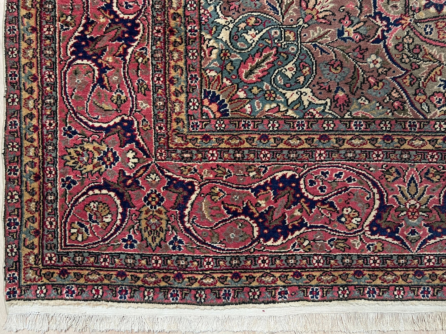 Corner border detail of a pink and brown vintage Kayseri Turkish rug, highlighting the intricate floral patterns and fine craftsmanship. This luxurious 9x12 handmade wool carpet is available in the San Francisco Bay Area with free shipping, perfect for adding a touch of elegance to any home decor.