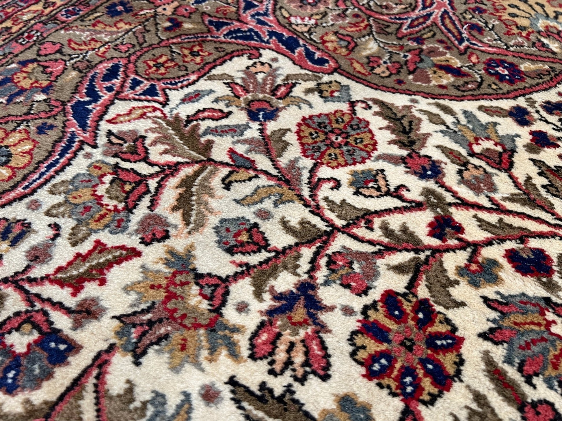 Floral background detail of a pink and brown vintage Kayseri Turkish rug. This luxurious 9x12 handmade wool carpet is available in the San Francisco Bay Area with free shipping, perfect for adding a touch of elegance to any home decor.