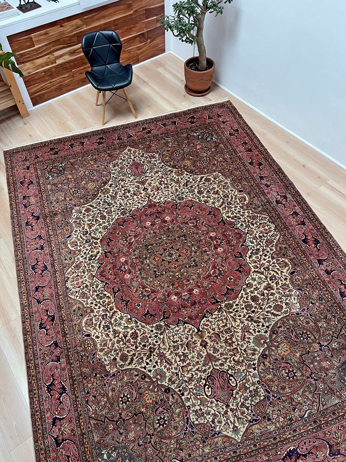 Side Angled view of a pink and brown vintage Kayseri Turkish rug, a luxurious 9x12 handmade wool carpet with a detailed floral pattern, showcased in a modern living room setting in the San Francisco Bay Area. Available with free shipping, perfect for enhancing any living room, bedroom, dining area, or office.