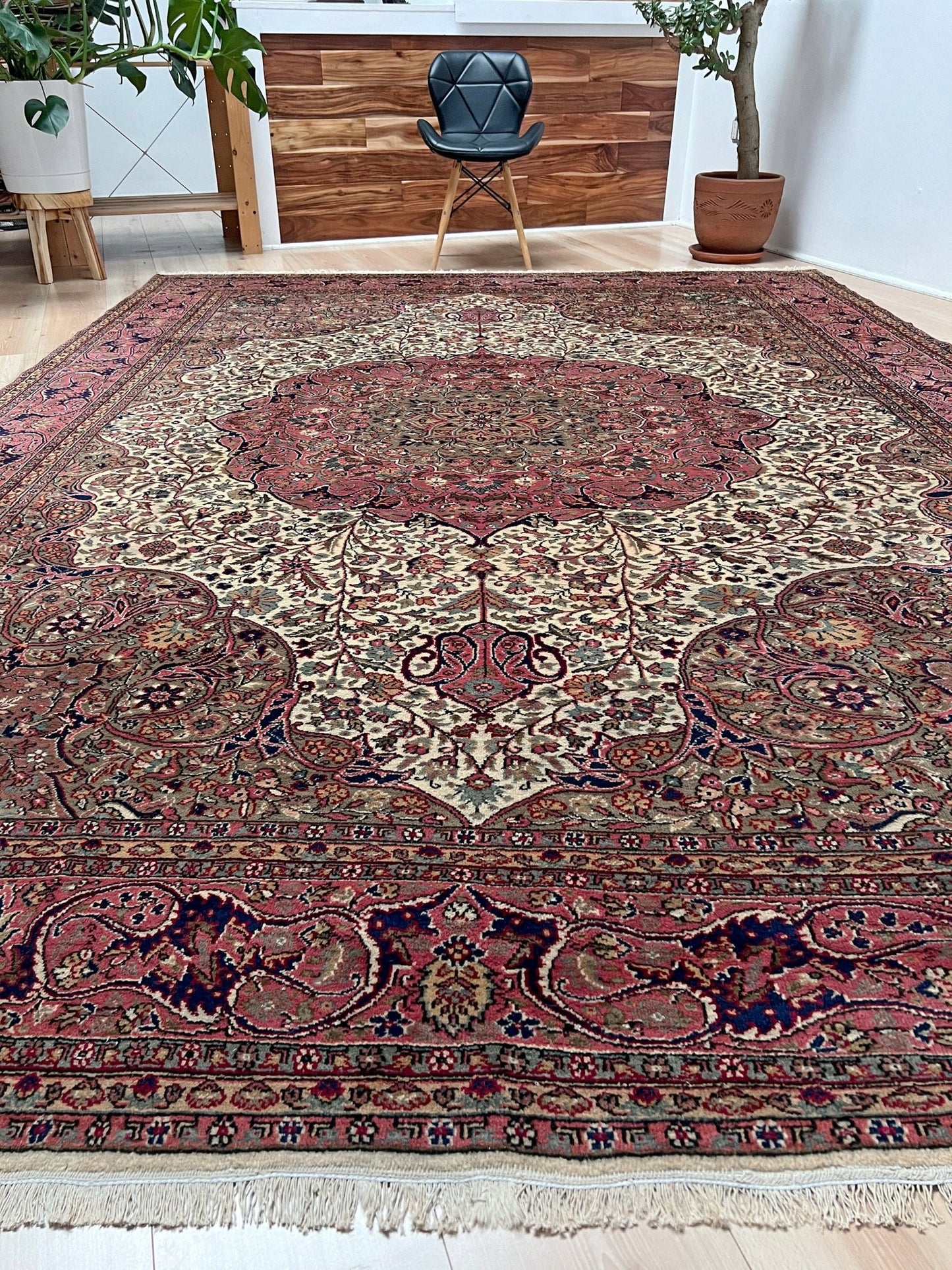 Angled view of a pink and brown vintage Kayseri Turkish rug, a luxurious 9x12 handmade wool carpet with a detailed floral pattern, showcased in a modern living room setting in the San Francisco Bay Area. Available with free shipping, perfect for enhancing any living room, bedroom, dining area, or office.