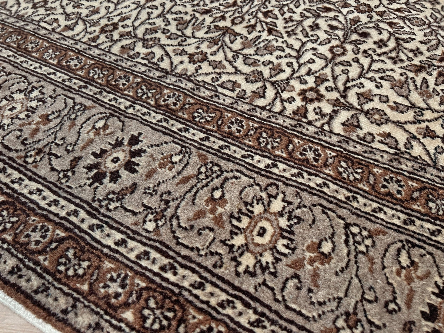 Close-up of a neutral Kayseri Turkish rug's intricate floral border design, handmade from undyed wool. The 8x12 wool carpet adds a touch of elegance to any living room, bedroom, dining area, or office decor. Free shipping from our rug shop in San Francisco Bay Area to USA and Canada.