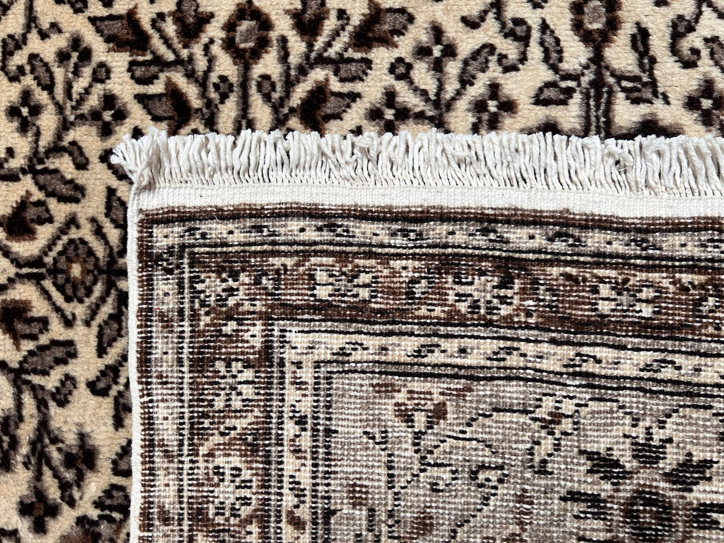 Close-up back of a neutral Kayseri Turkish rug's intricate floral border design, handmade from undyed wool. The 8x12 wool carpet adds a touch of elegance to any living room, bedroom, dining area, or office decor. Free shipping from our rug shop in San Francisco Bay Area to USA and Canada.