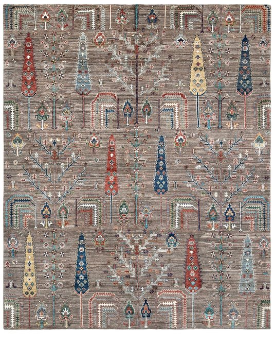 A square area rug with a complex, symmetrical tribal pattern in muted earth tones, featuring a central tree motif and stylized geometric tree-like shapes in red, blue, beige, and gray on a taupe-brown background. 8x10 Taupe Tree of Life Turkish rug with borderless floral garden design, stylized trees, handmade wool from Indigo Rugs Burlingame Bay Area.