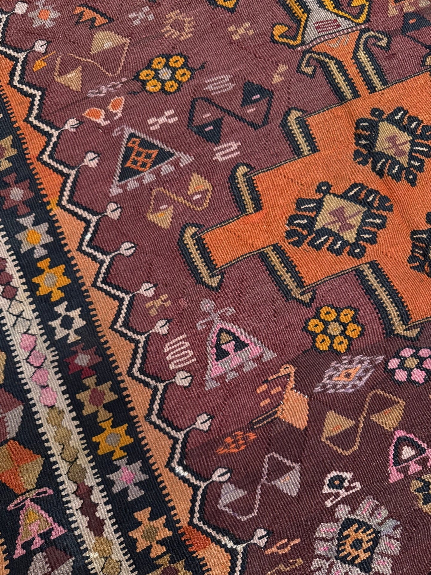 Vintage Kurdish Kars kilim, featuring maroon red and chestnut brown field, geometric medallions, symbolic tribal motifs and protective symbols, handwoven wool 5x10 flatweave rug 