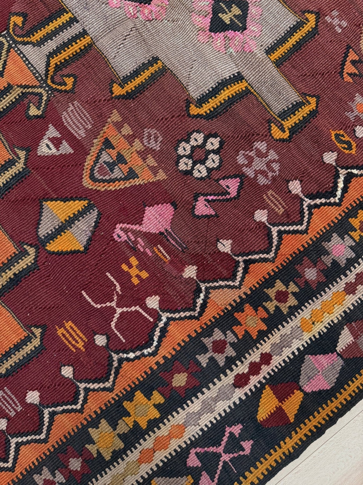 Vintage Kurdish Kars kilim, featuring maroon red and chestnut brown field, geometric medallions, symbolic tribal motifs and protective symbols, handwoven wool 5x10 flatweave rug 